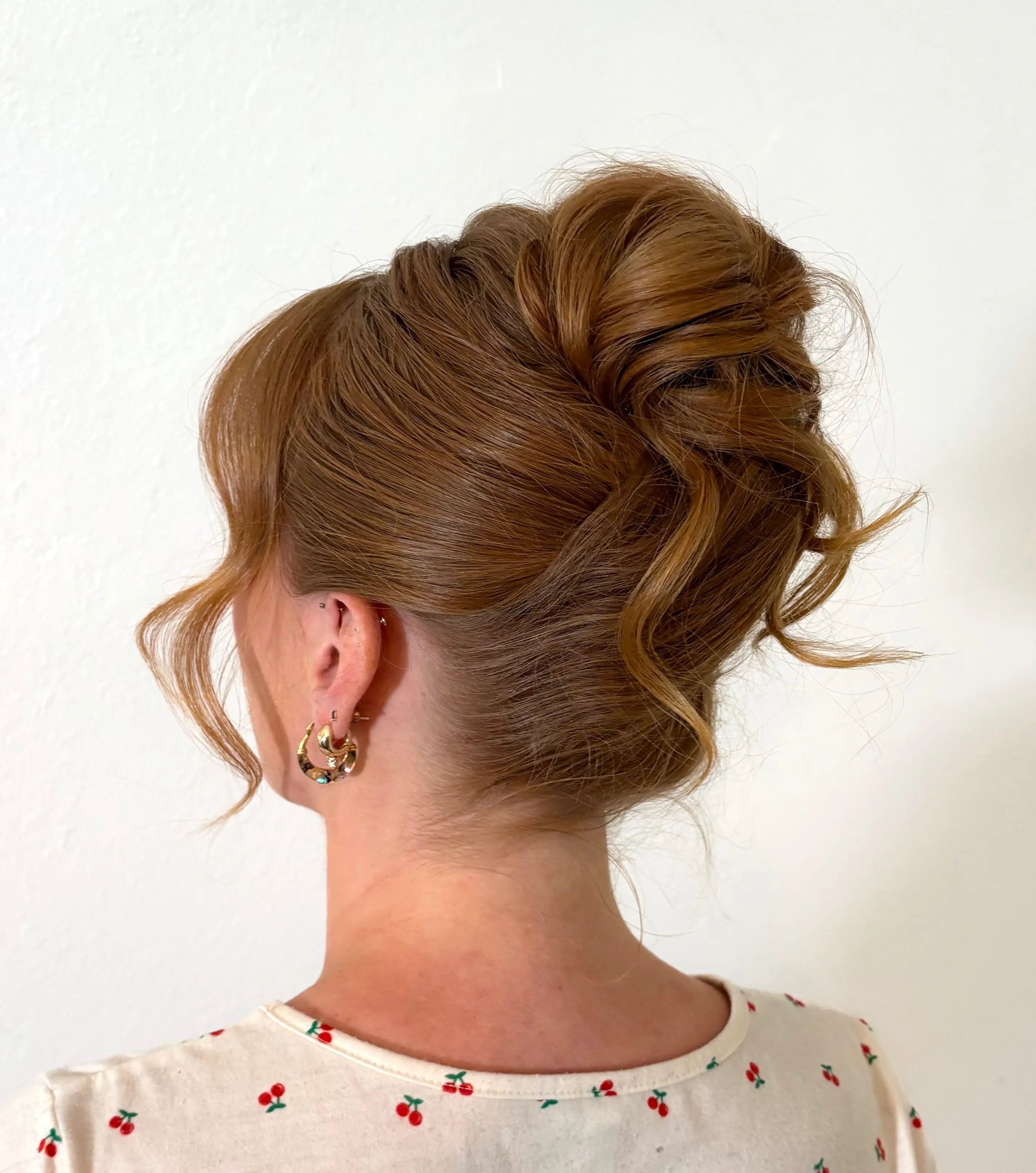 Airy high updo with loose curled ends and side tendrils
