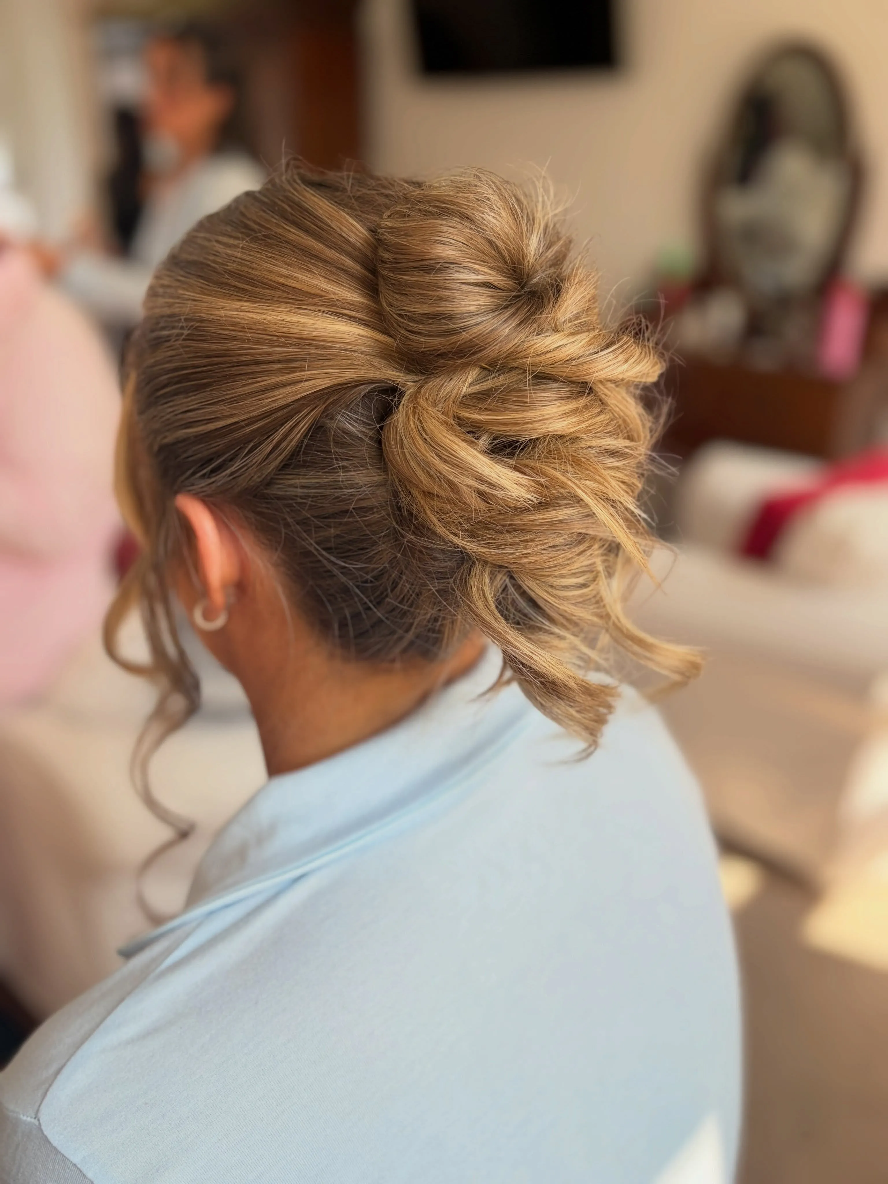 Braided textured bun with loose curled pieces