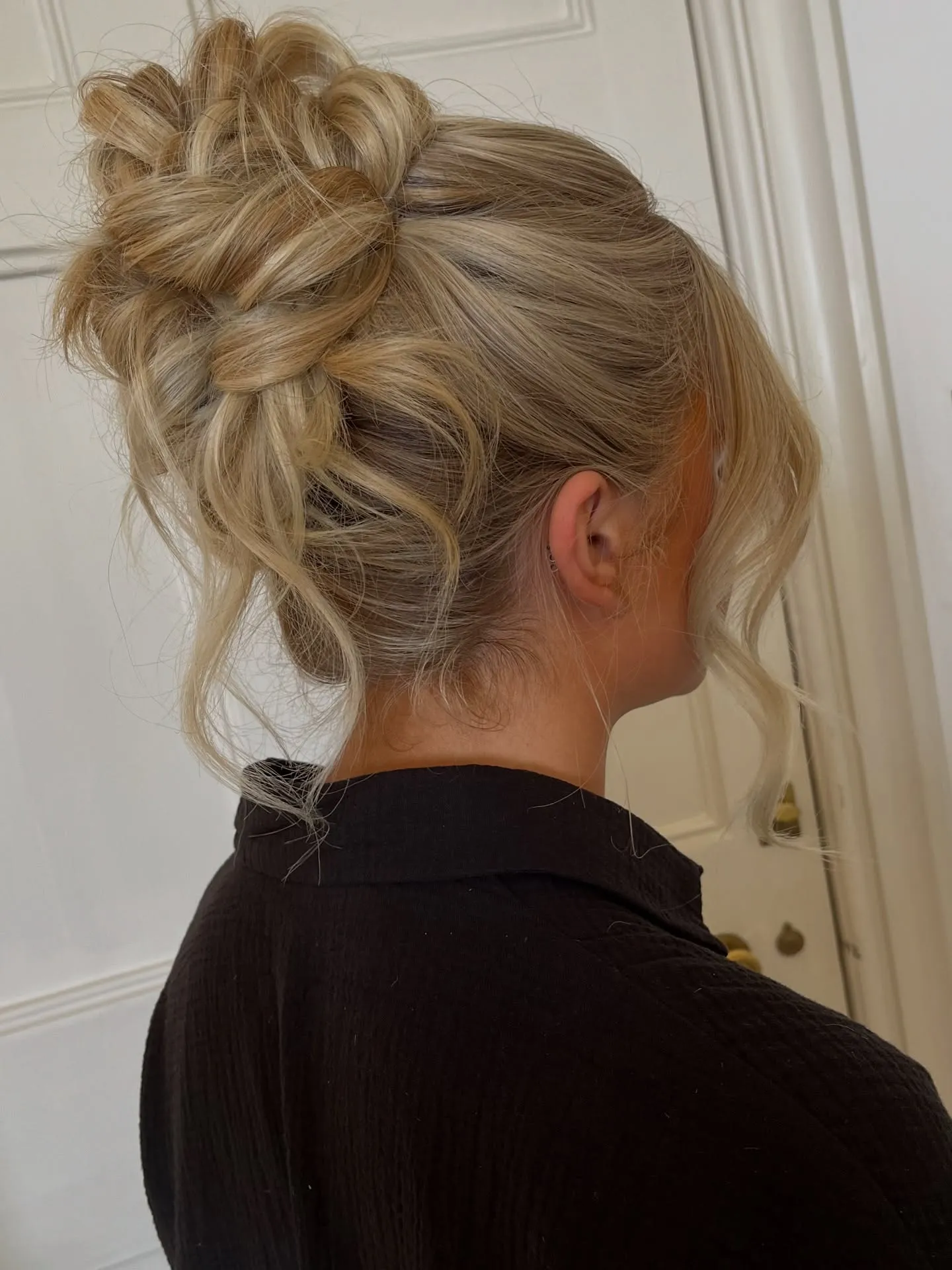 Voluminous high bun with loose curled front pieces