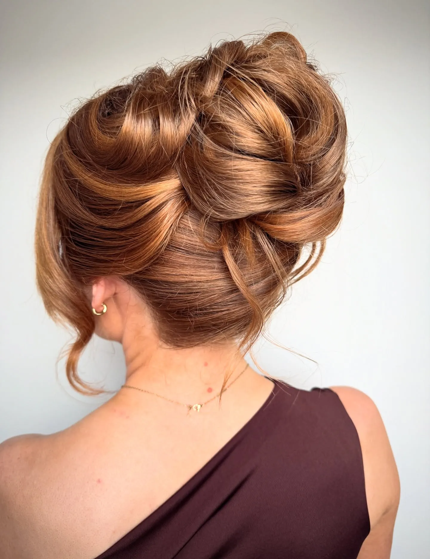 Sculpted twisted updo with rounded side volume