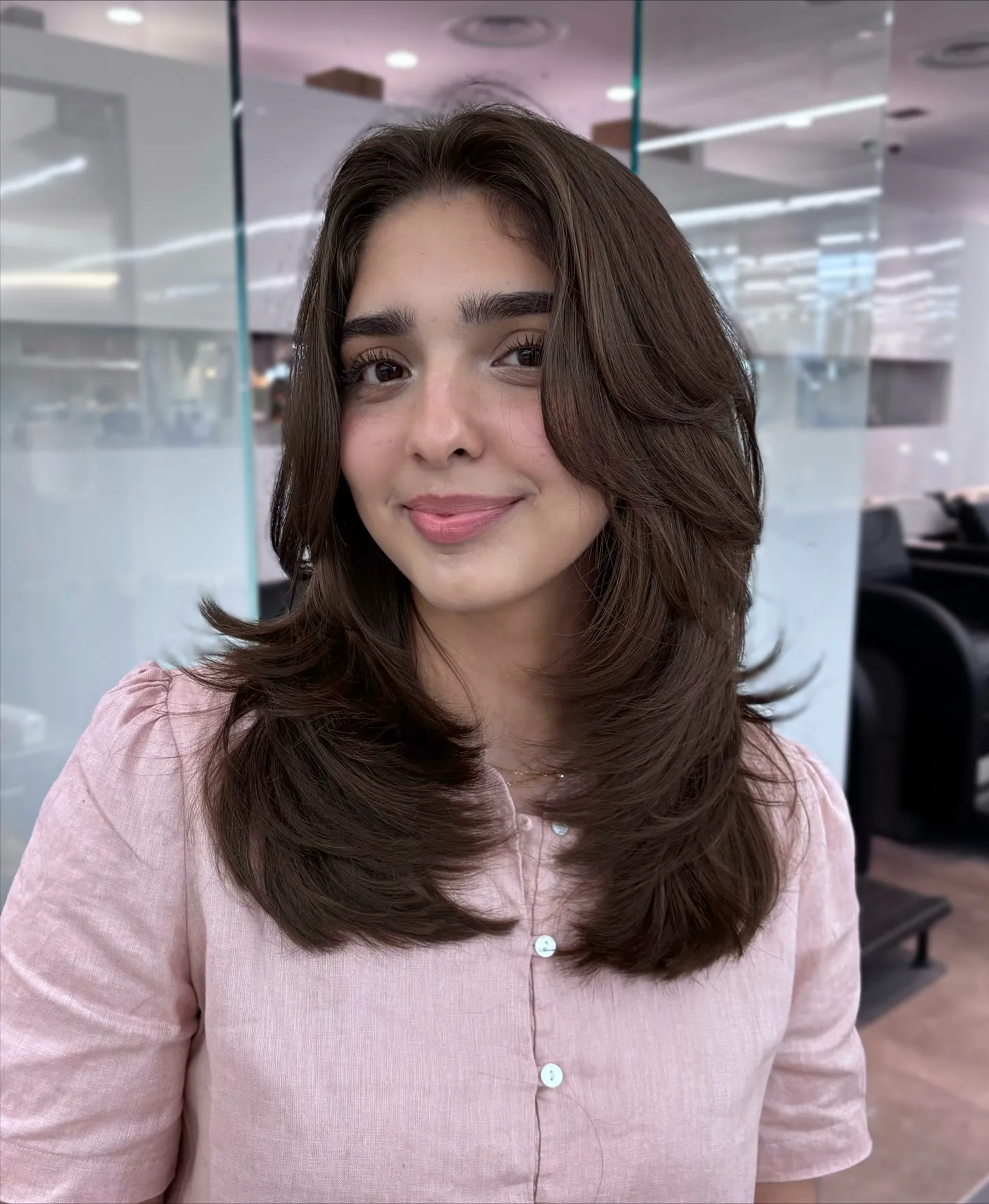 Dark brunette butterfly haircut with long curtain layers and flipped ends