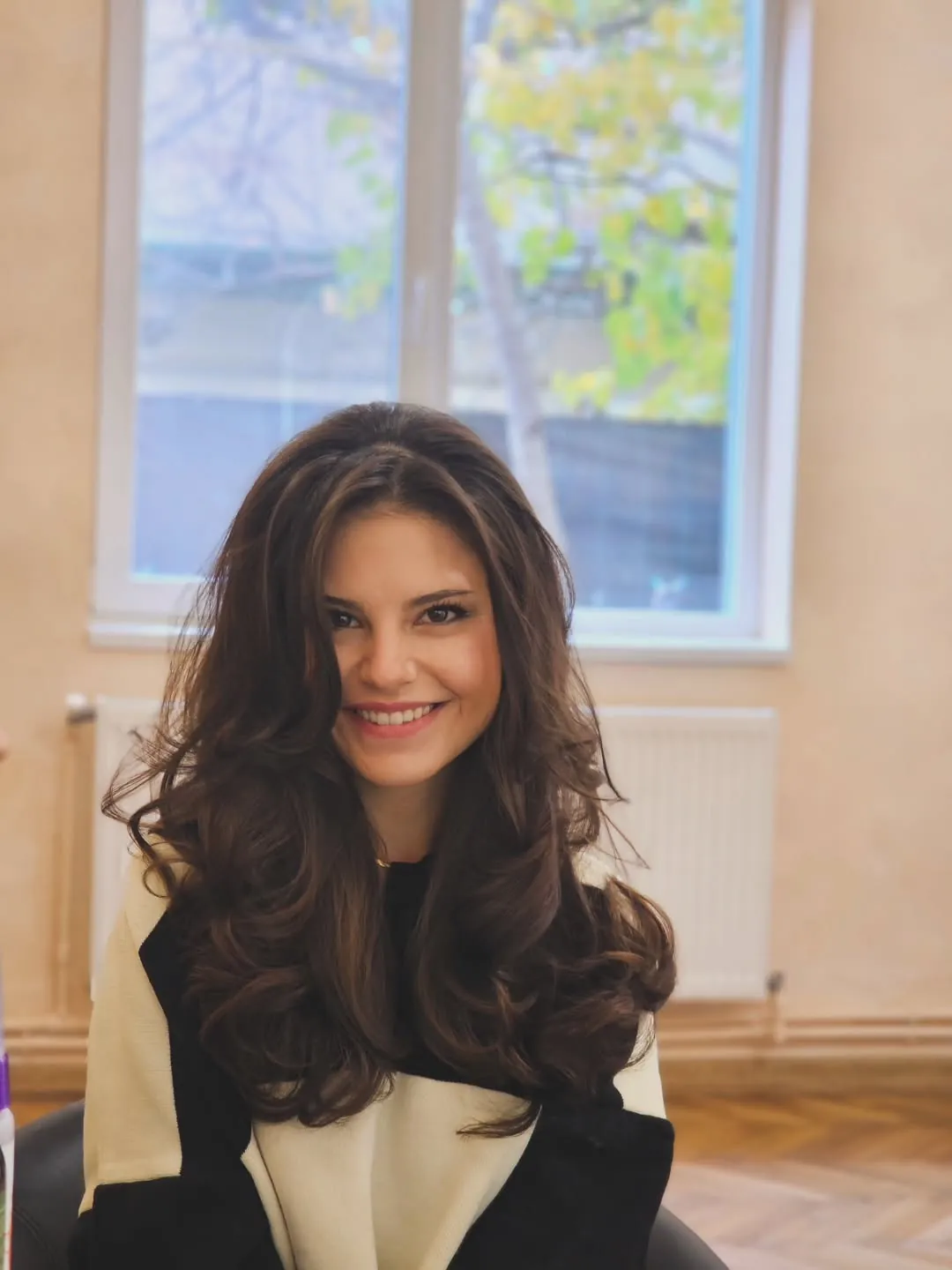 Long brunette butterfly haircut styled with cascading curls