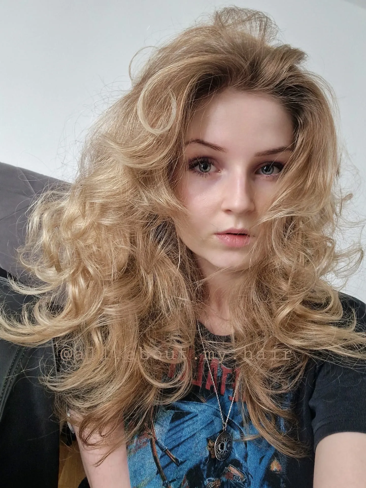 Blonde butterfly haircut with voluminous curls and layered shape