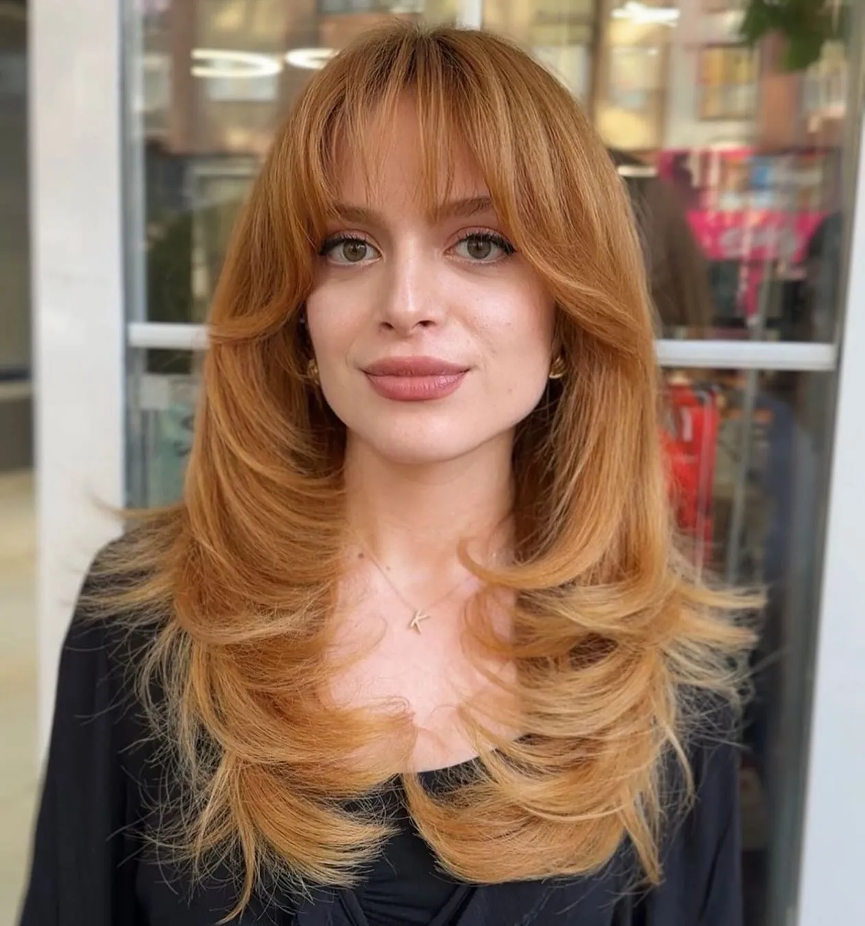 Copper butterfly haircut with full fringe and feathered long layers