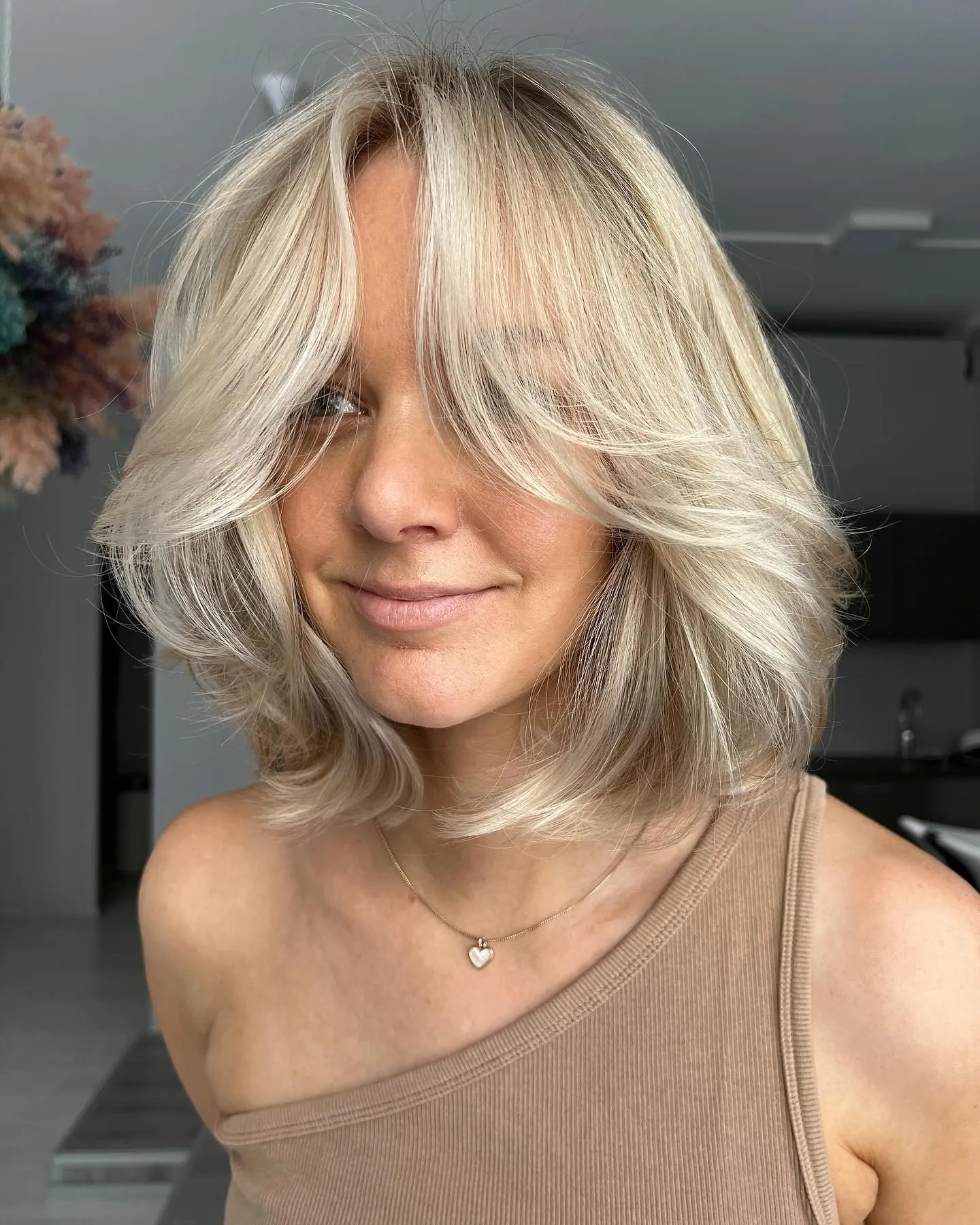 Platinum blonde collarbone butterfly cut with curtain bangs
