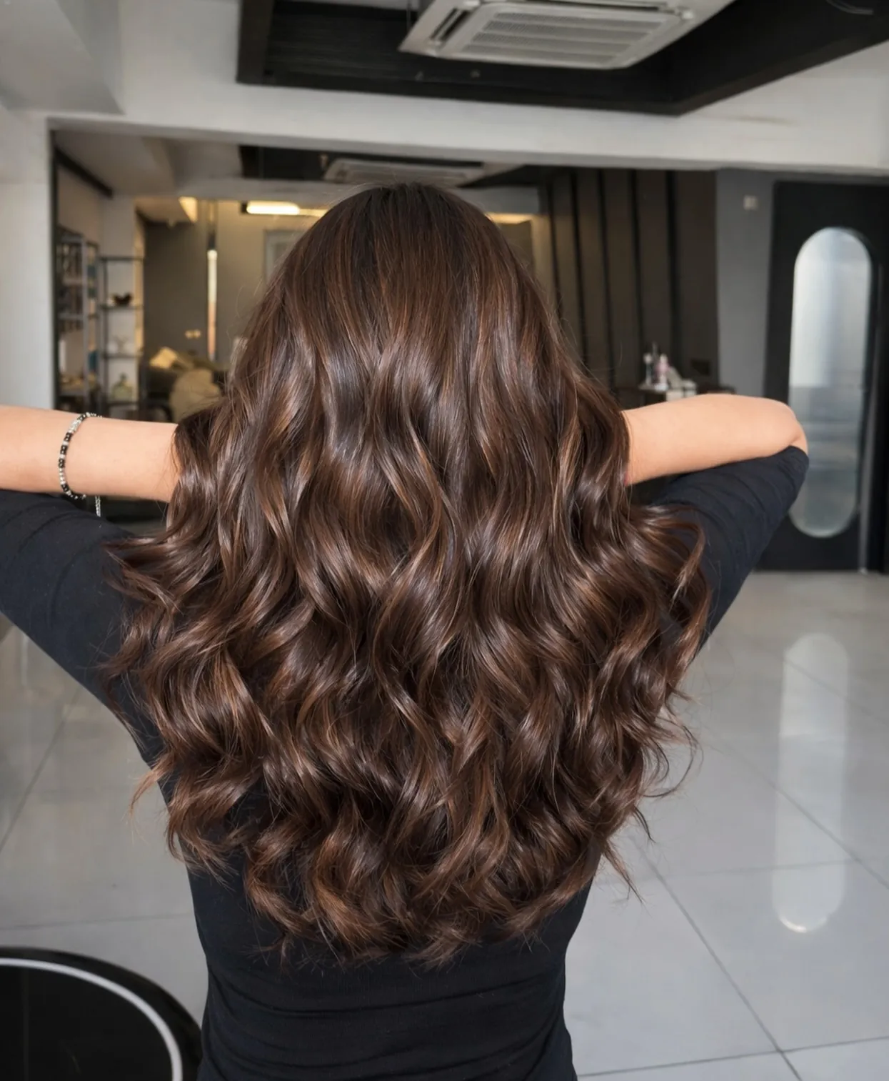 Glossy dark brunette hair with soft warm waves