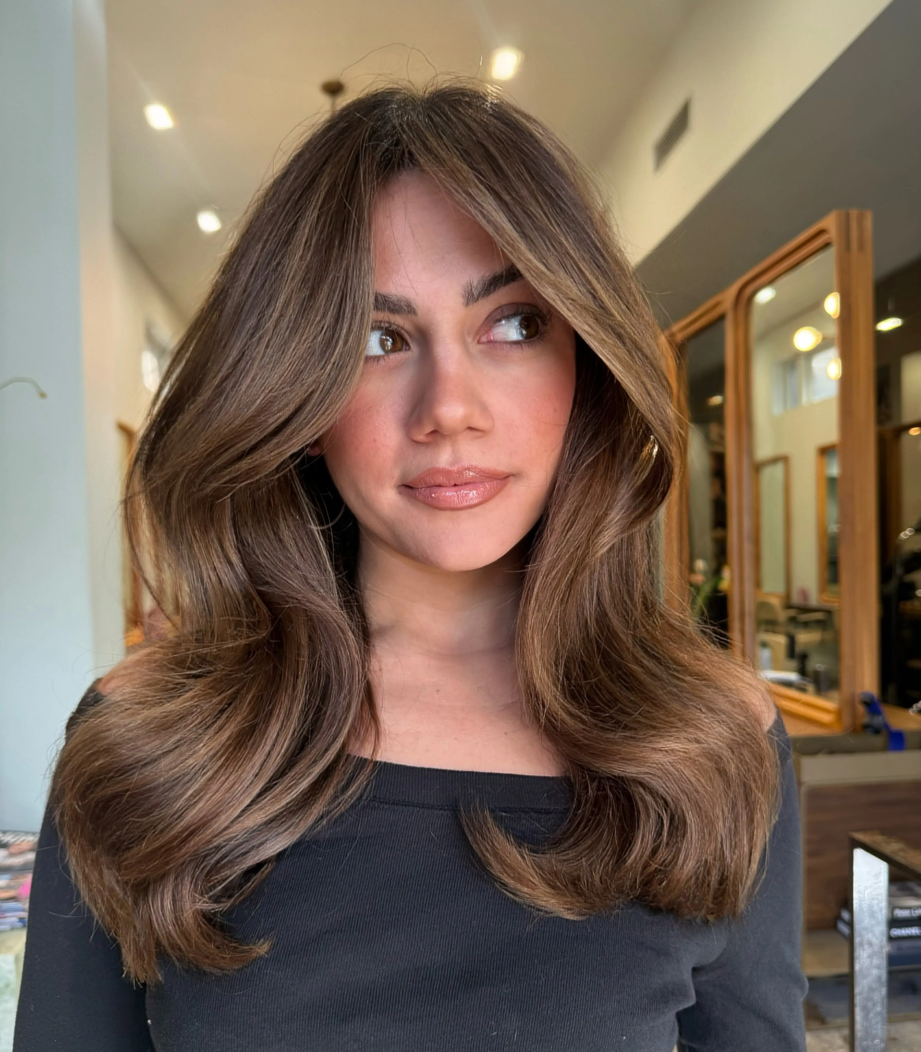 Warm brunette hair with curtain layers and lighter face framing