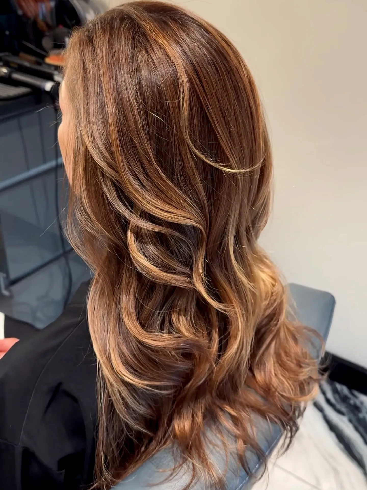 Back view of dimensional warm brown waves and layered highlights