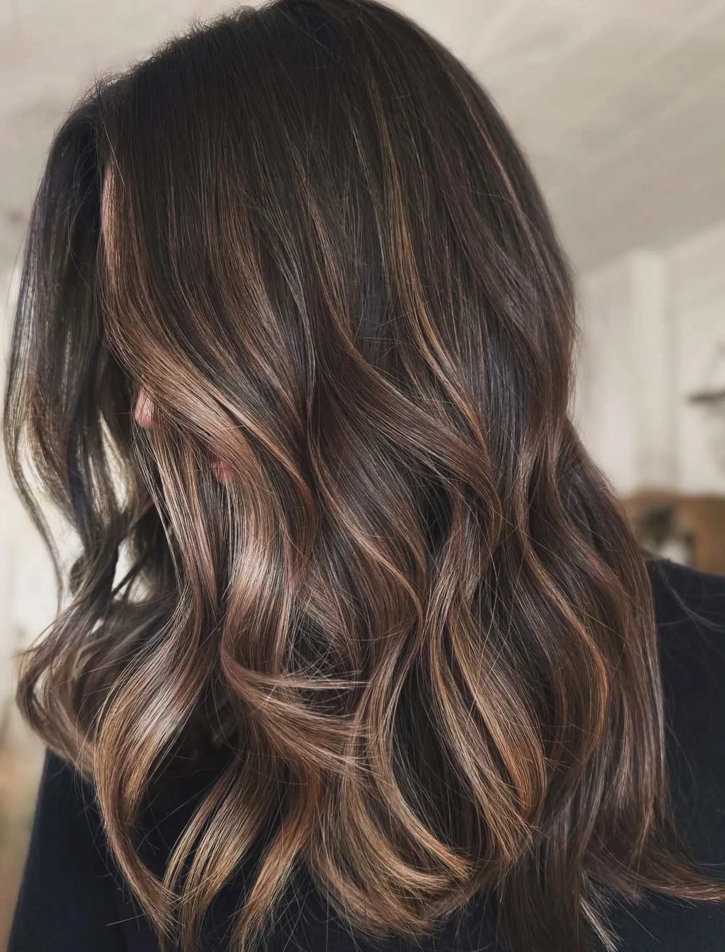 Dark brunette waves with bold warm ribbon highlights
