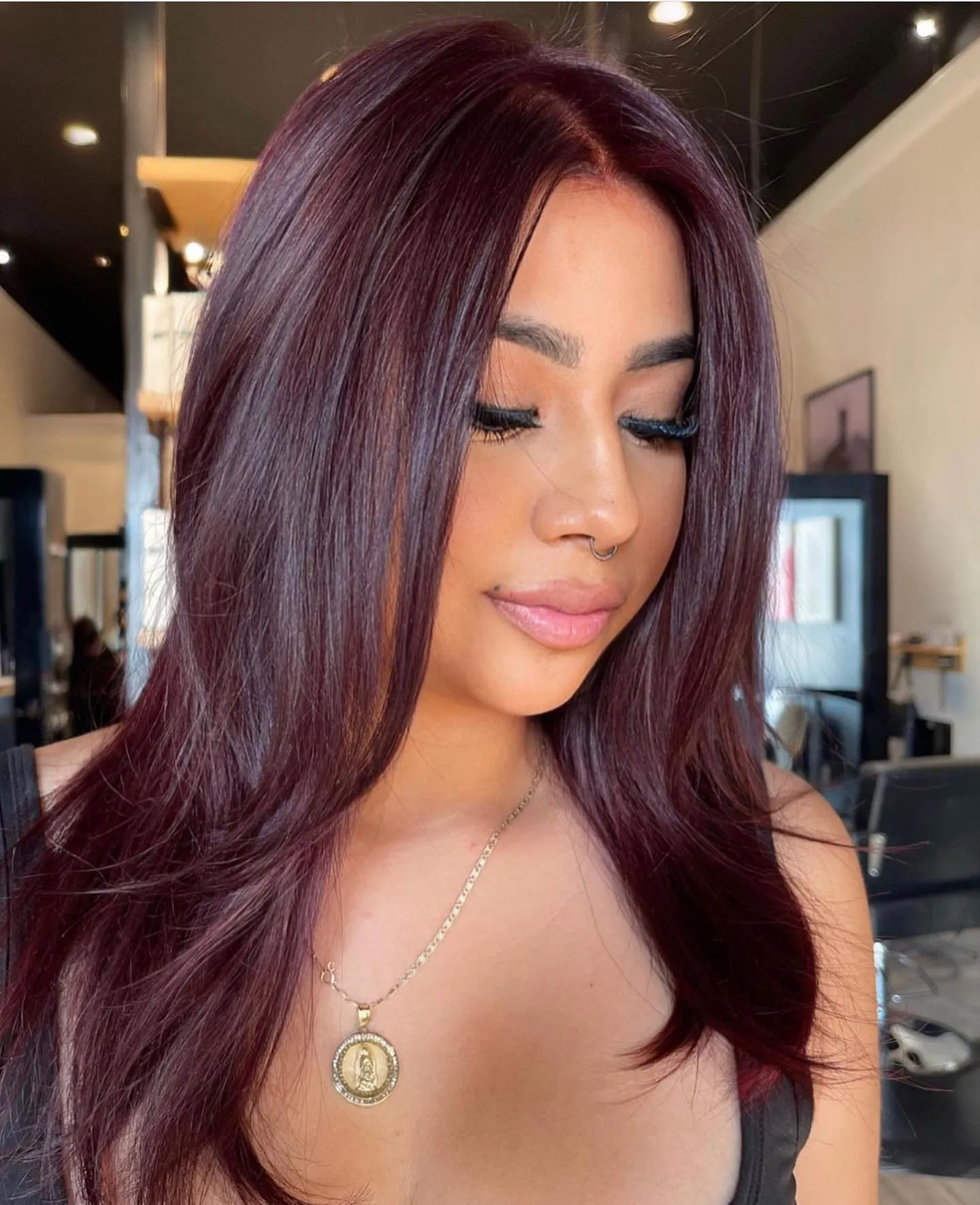 Long straight layered hair in a deep burgundy red shade