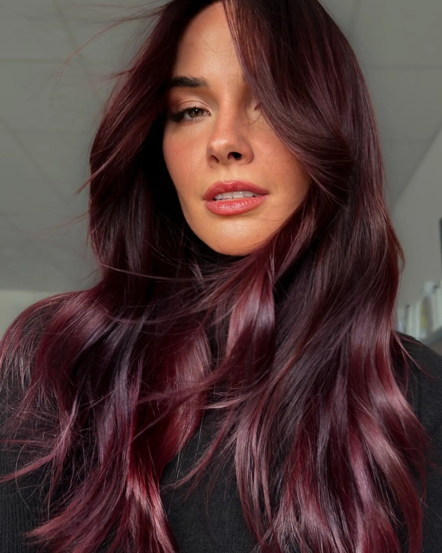 Long layered waves with deep plum and burgundy red tones