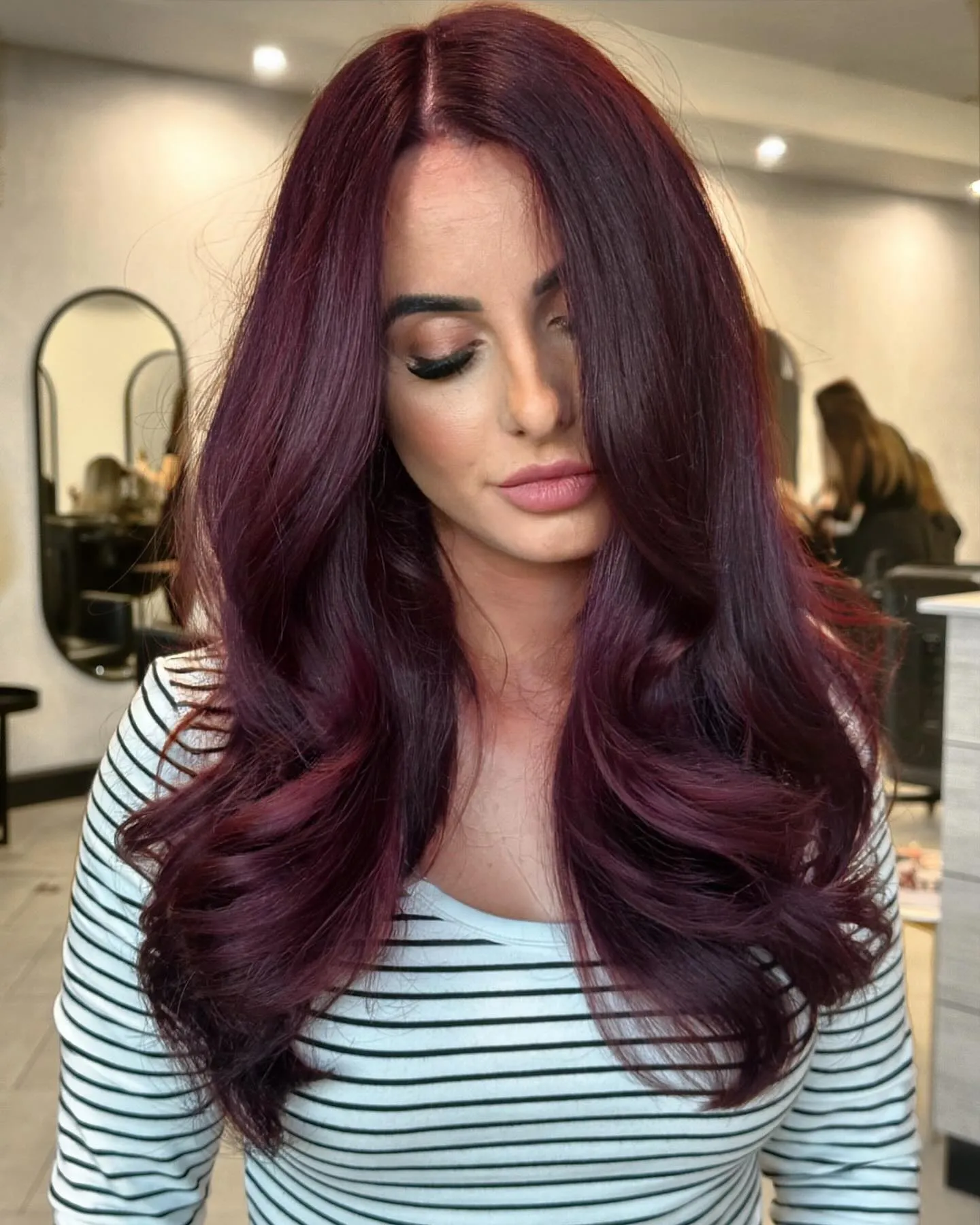 Long plum burgundy hair with smooth face-framing blowout layers