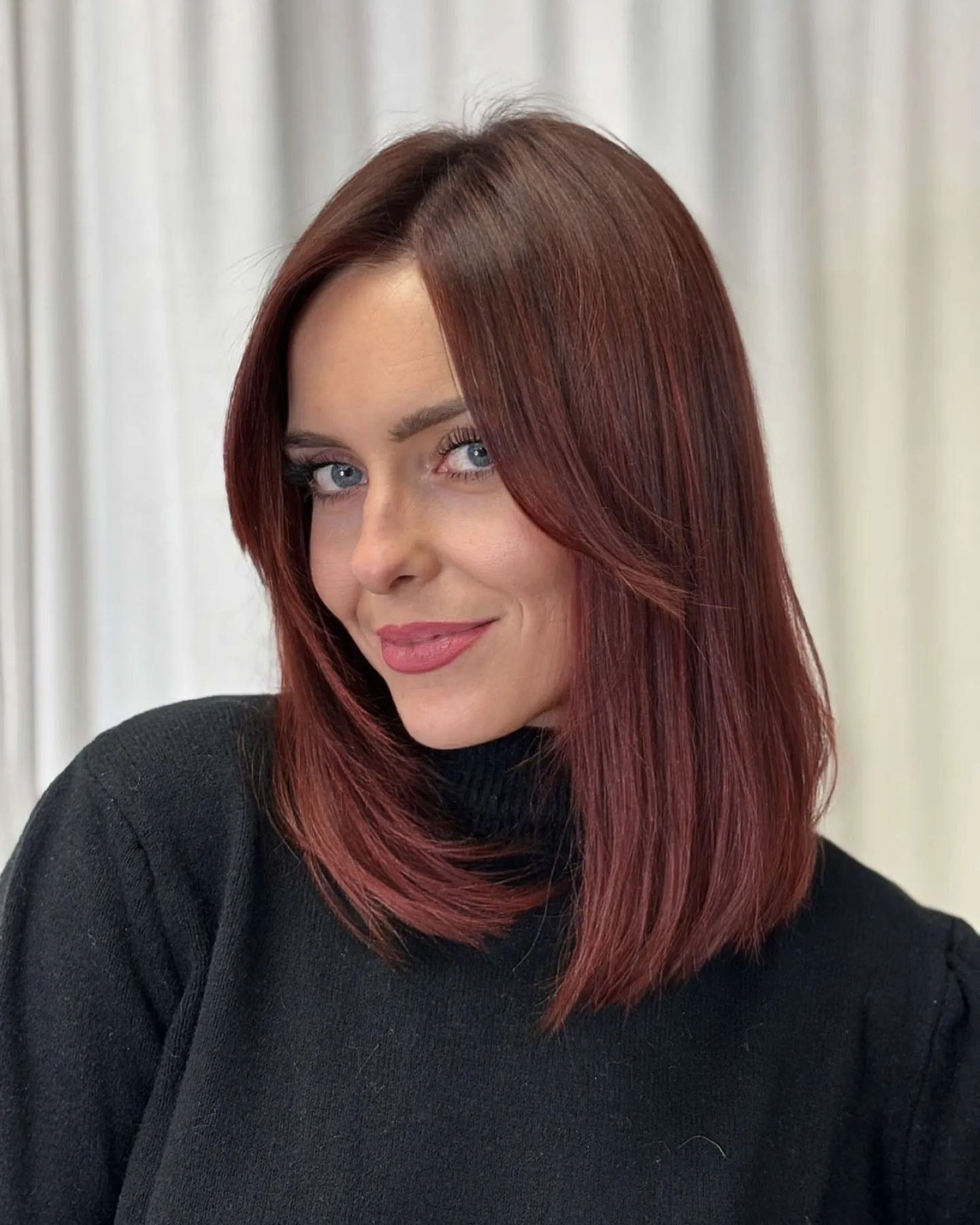 Blunt shoulder-length lob in a muted burgundy red shade