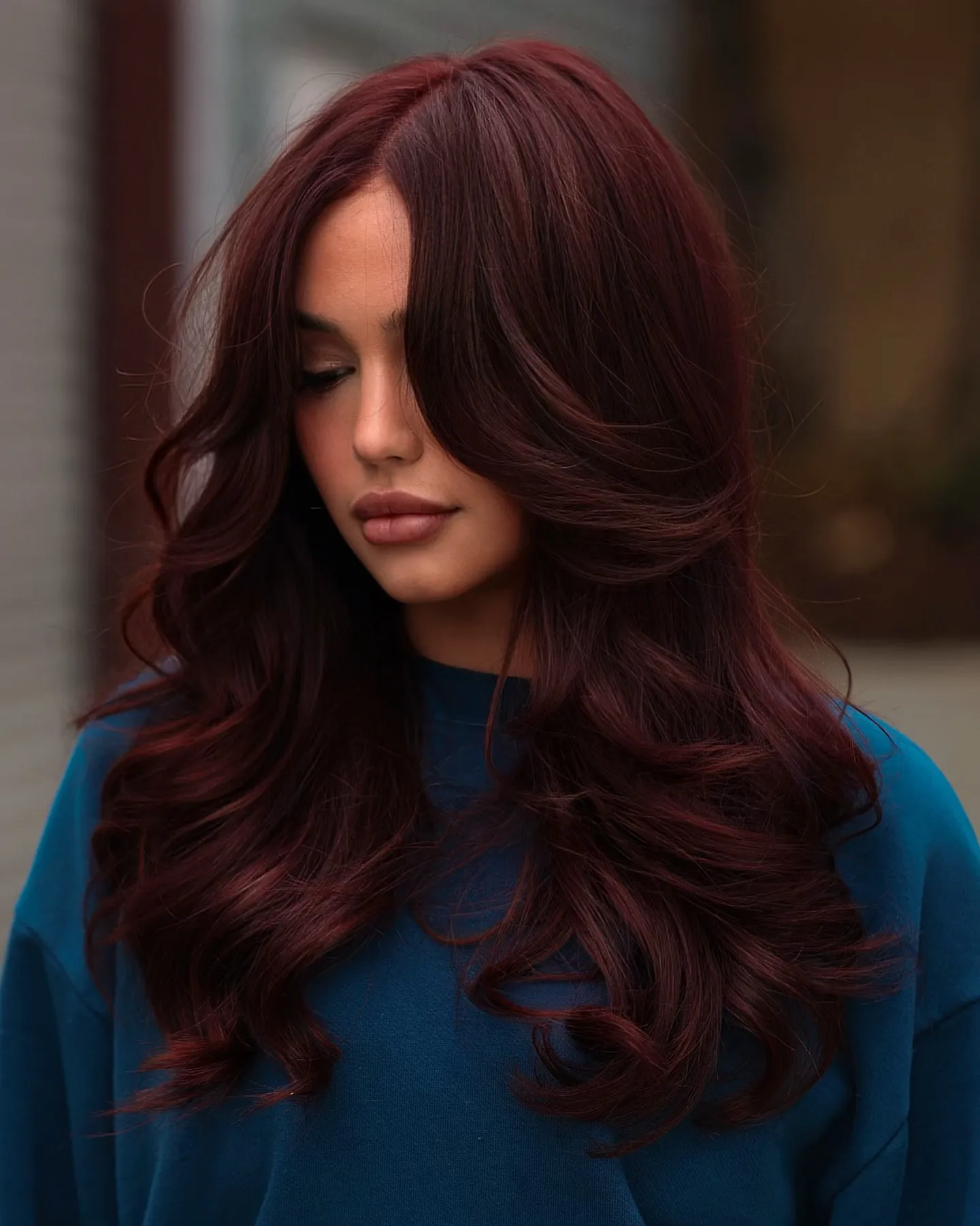 Long dark red layered hair with soft glossy waves