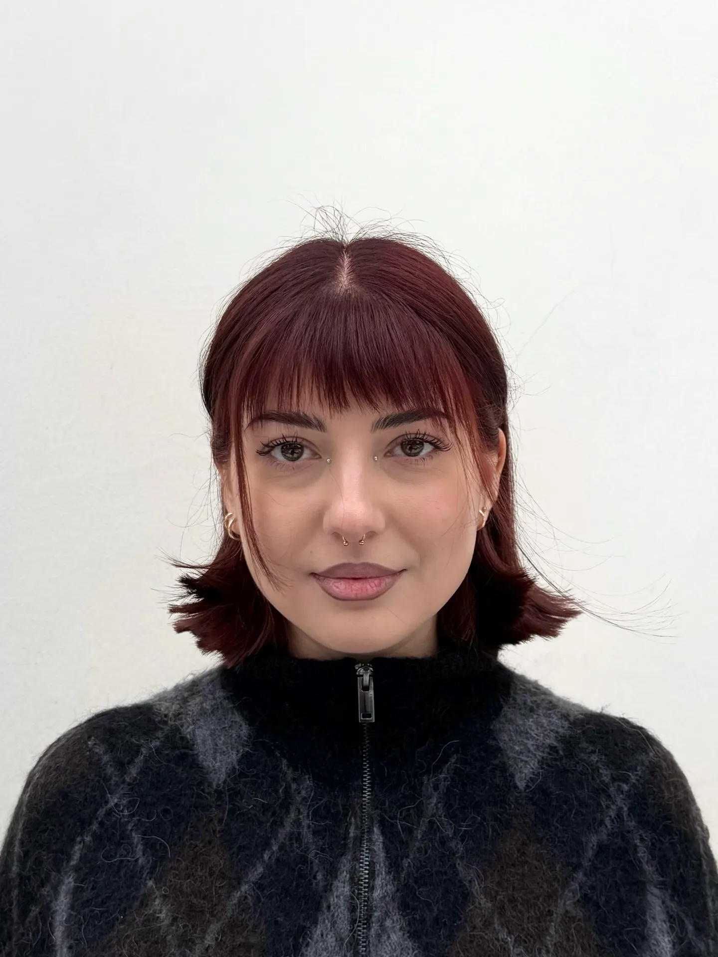 Short red bob with micro bangs and outward flipped ends