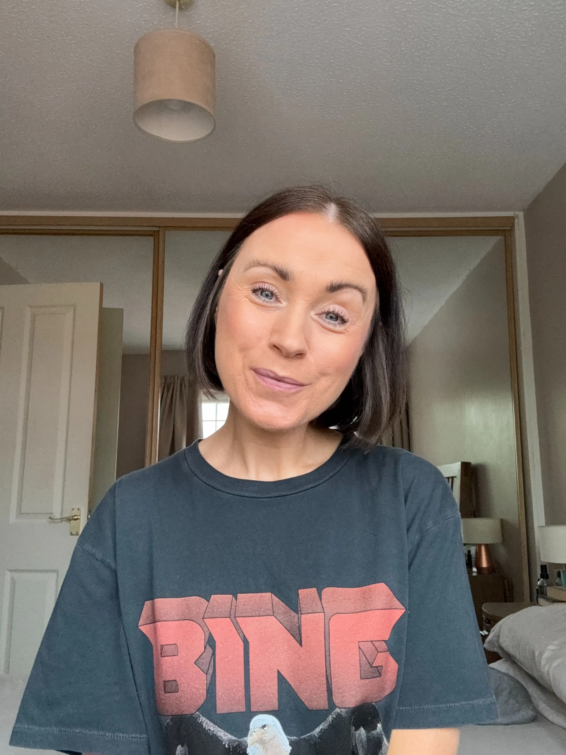 Straight dark chin-length bob with a centre part and sides tucked behind the ears