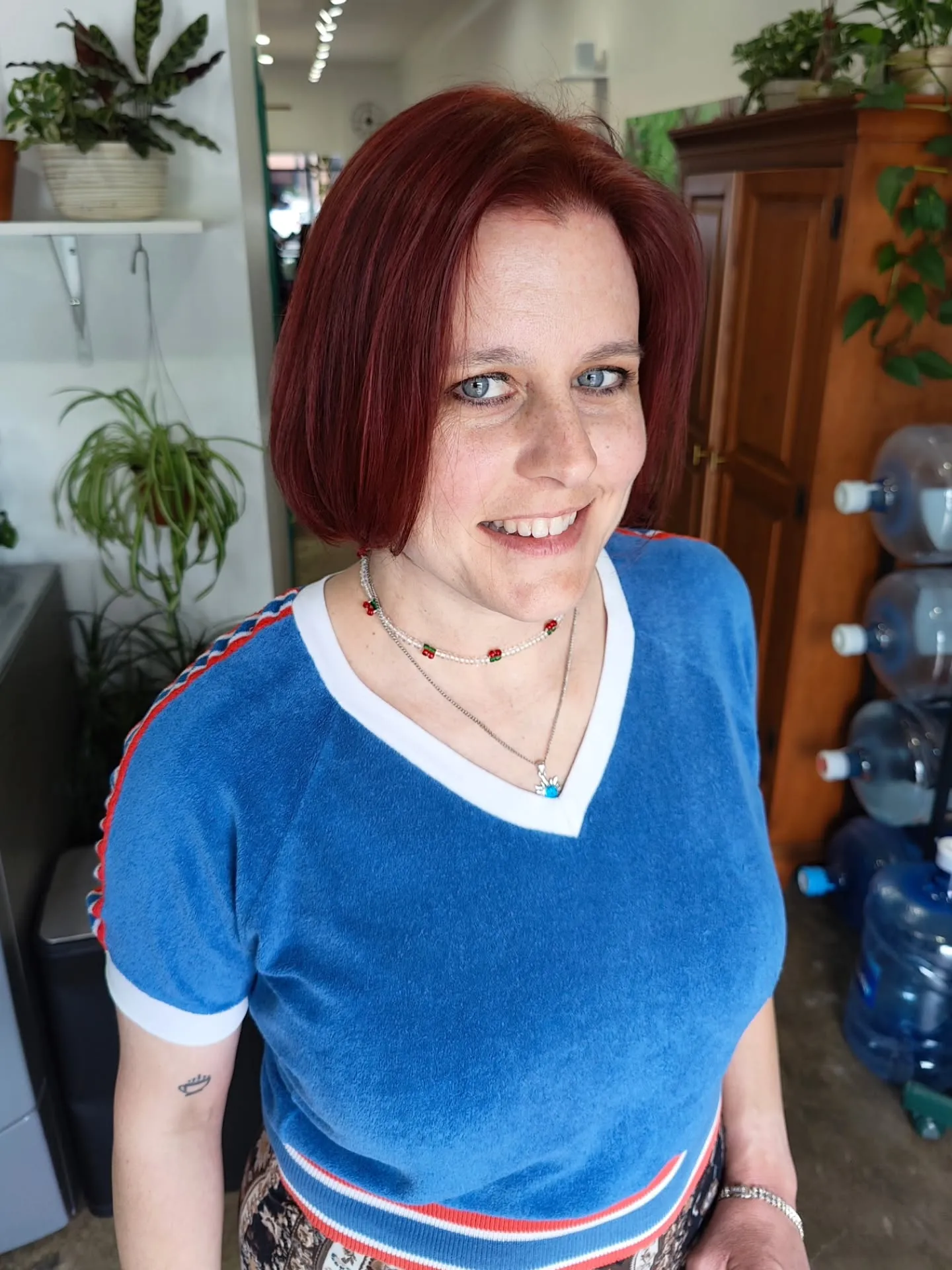 Deep red chin-length blunt bob with a side part and one side tucked back