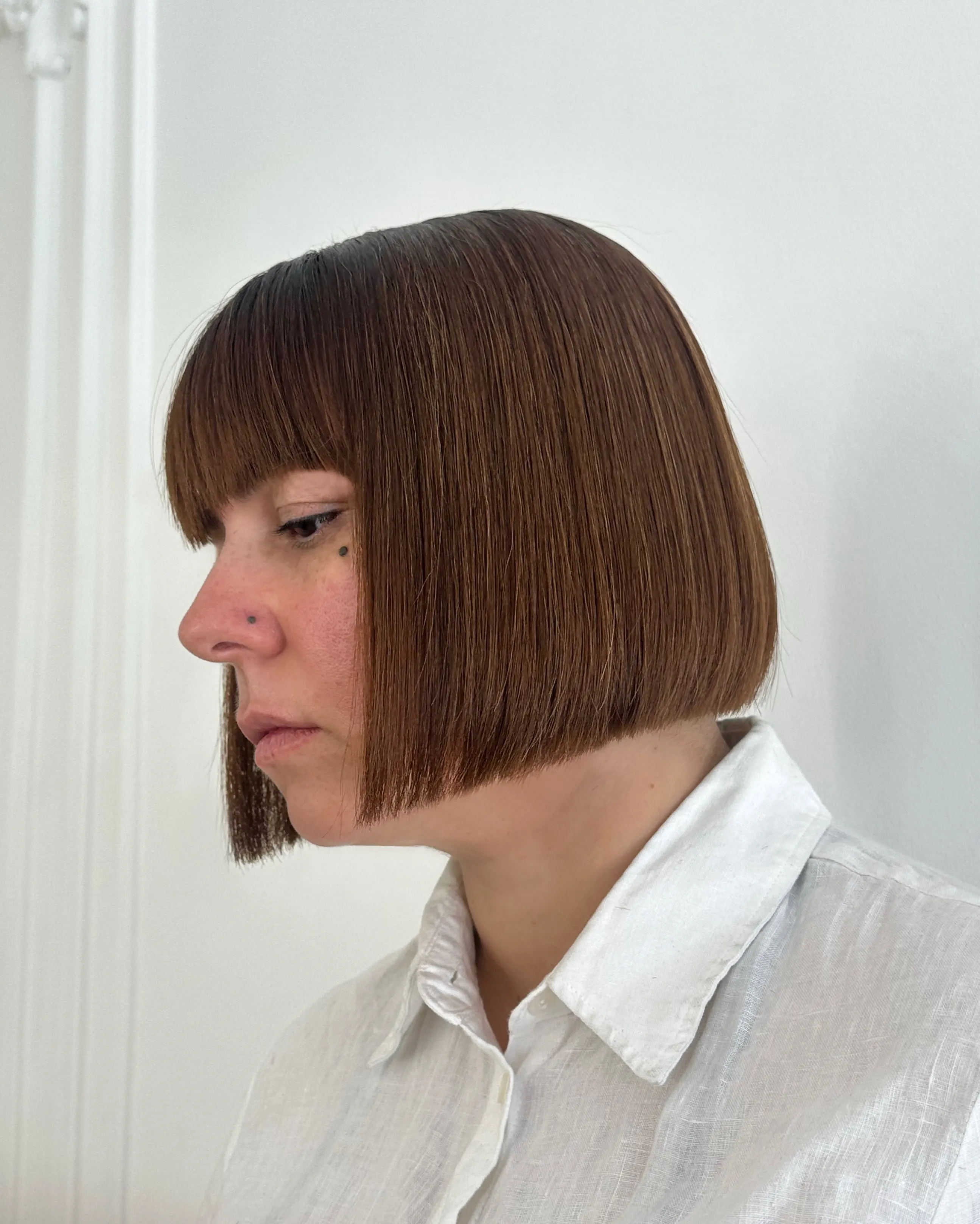 Precision brunette chin-length bob with a full straight fringe