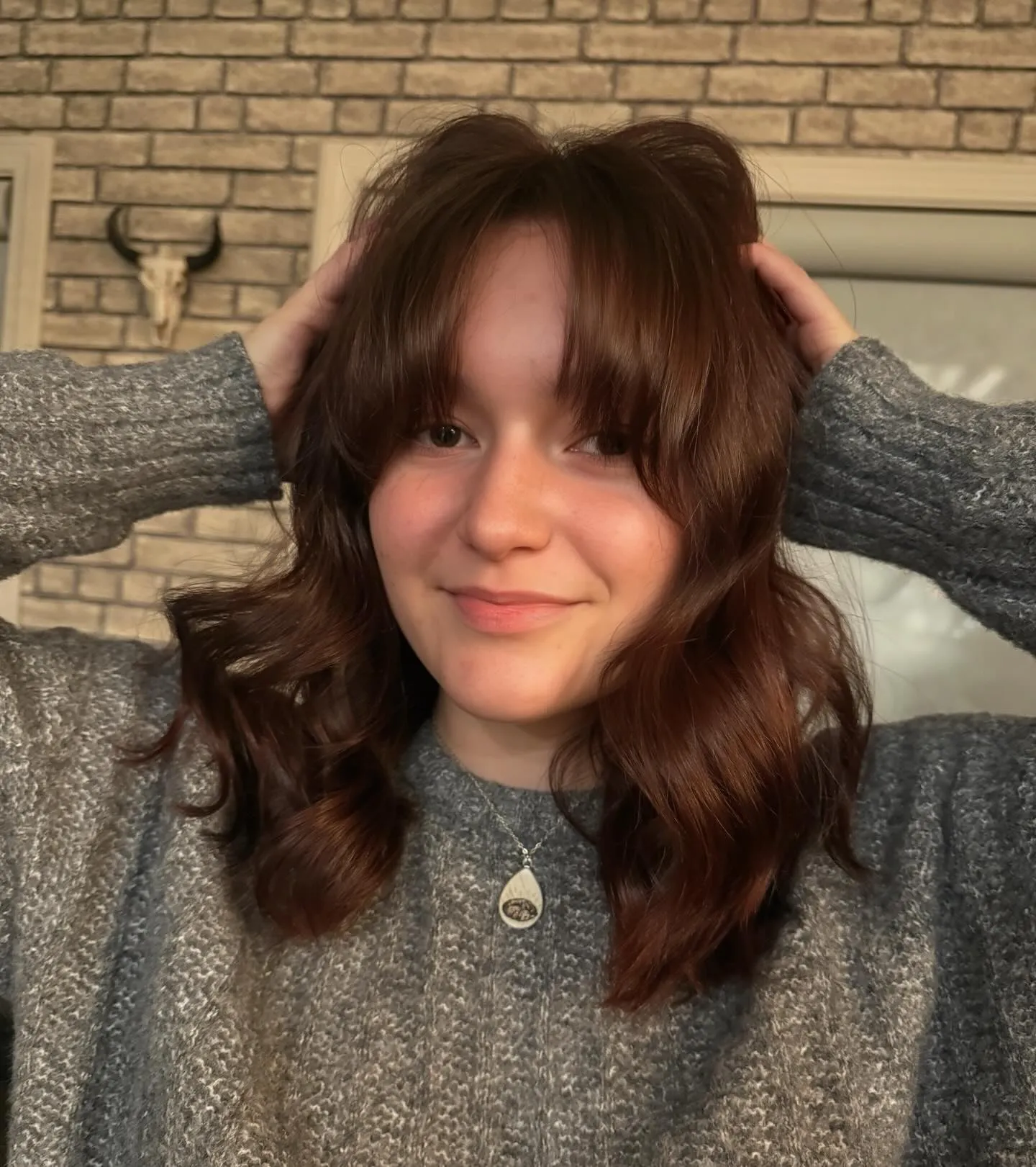 Soft wavy lob with deep red-brown hair color and curtain fringe