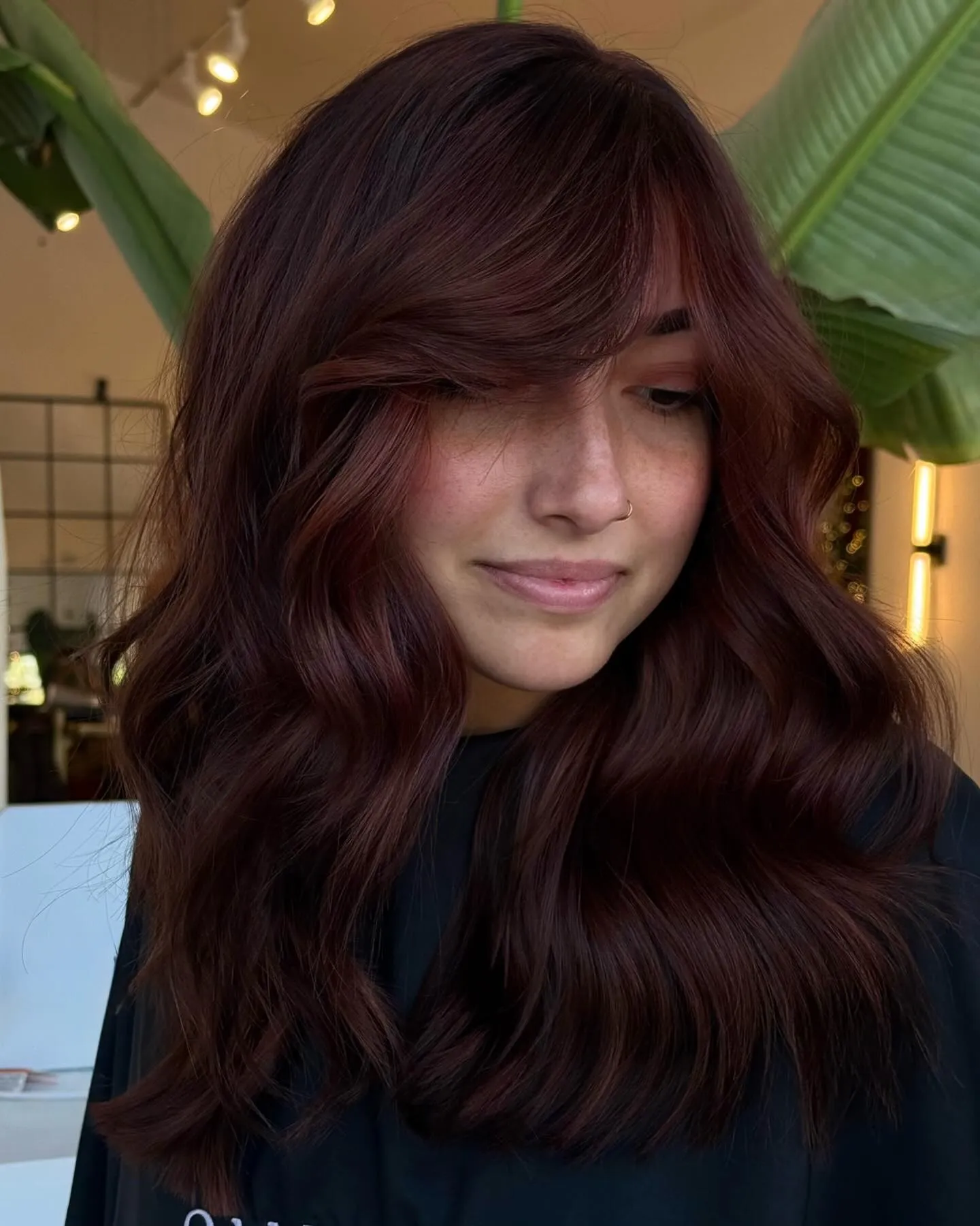 Long side-swept waves with deep red-brown hair color