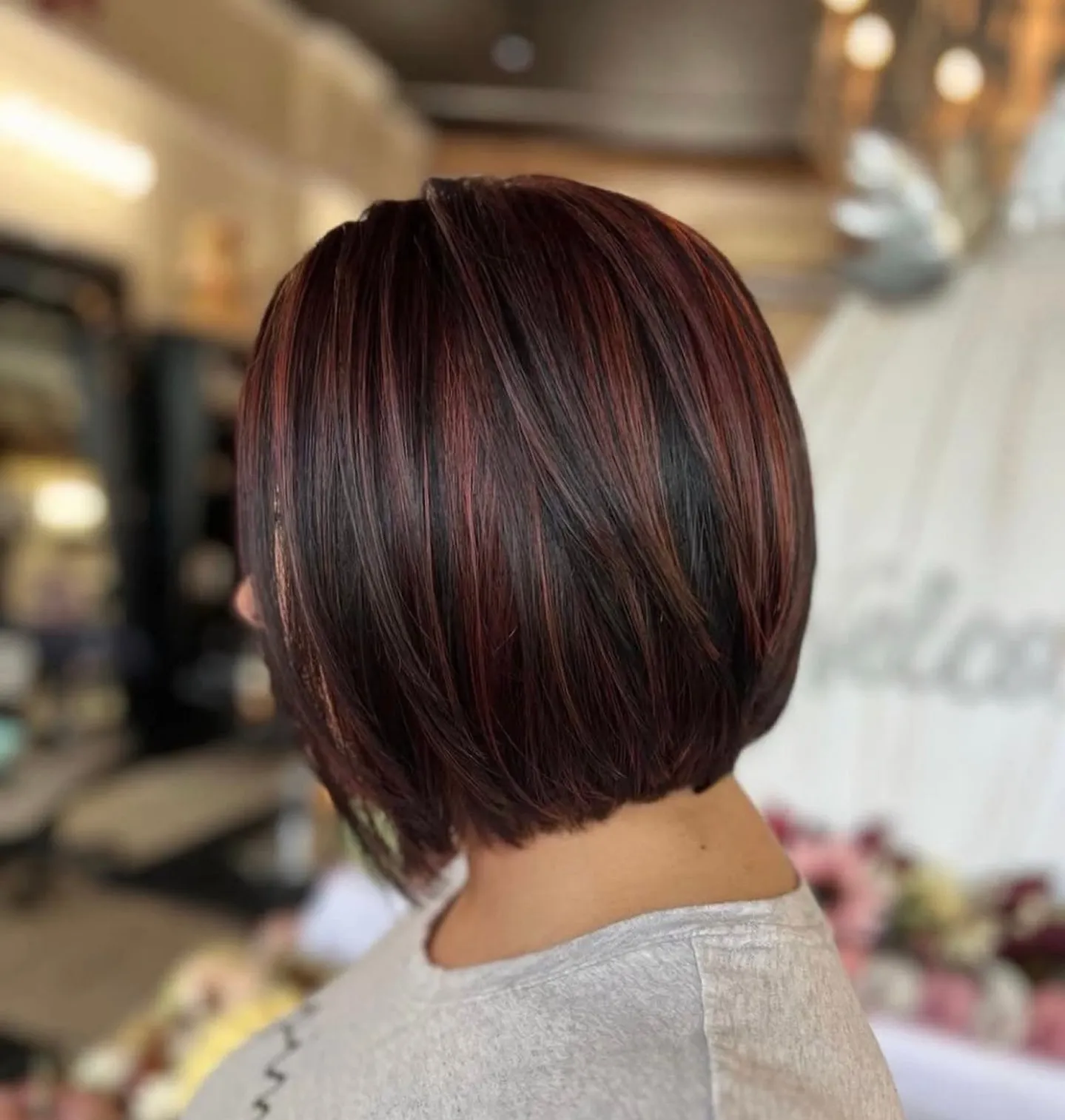 Rounded bob with dark brown base and fine burgundy red streaks