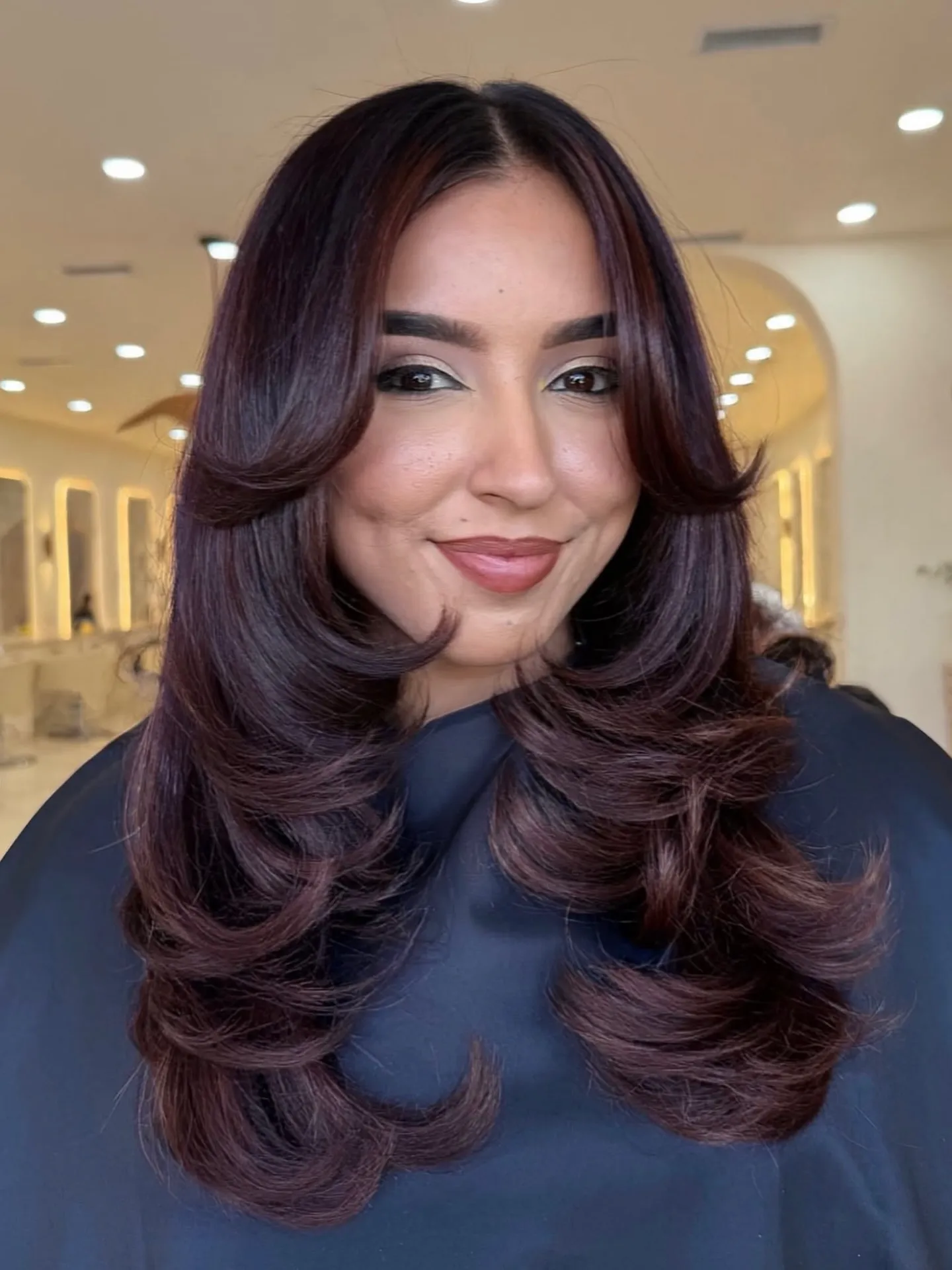 Voluminous long layers with deep violet-red brown hair color