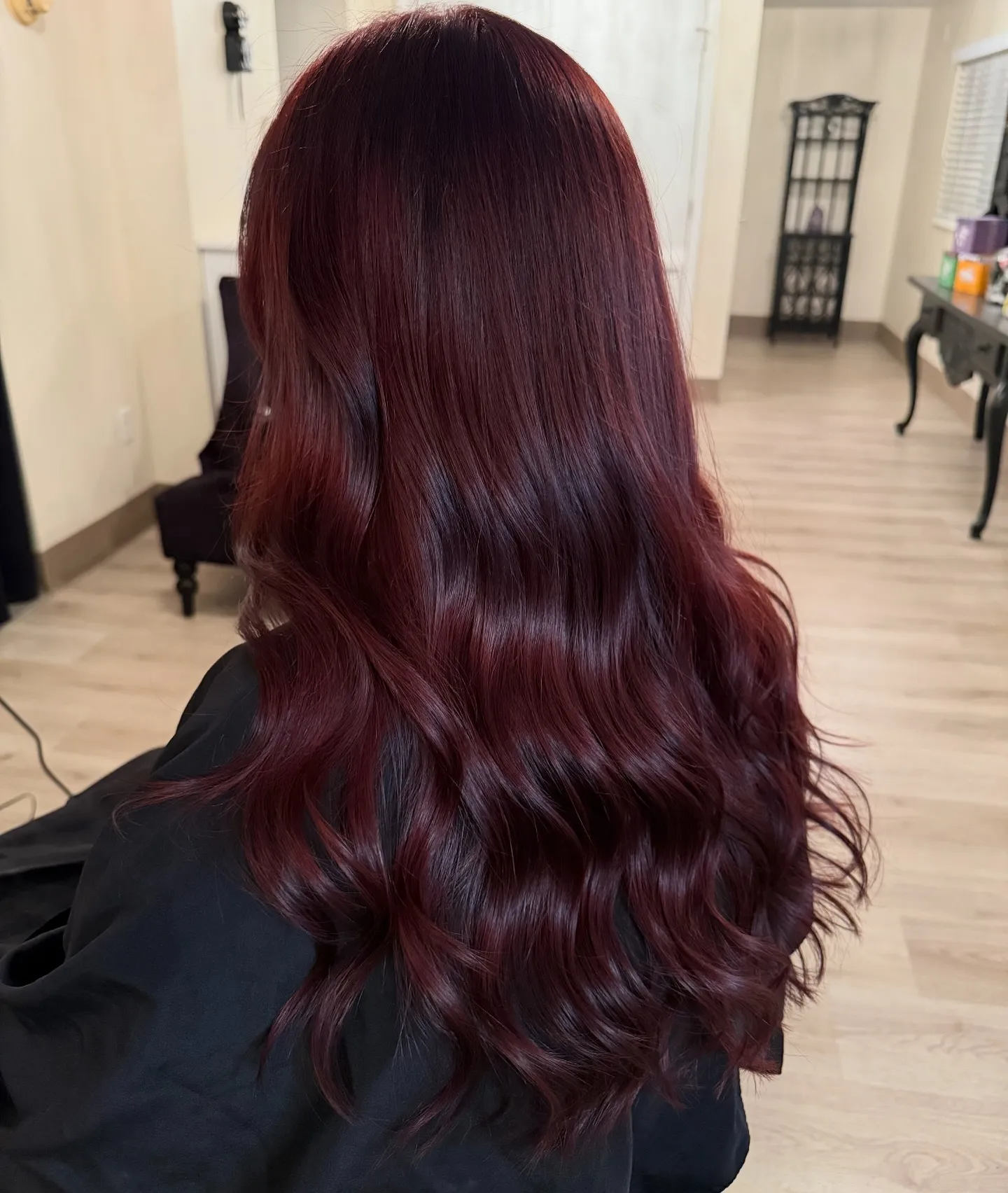 Long glossy waves with rich dark burgundy hair color