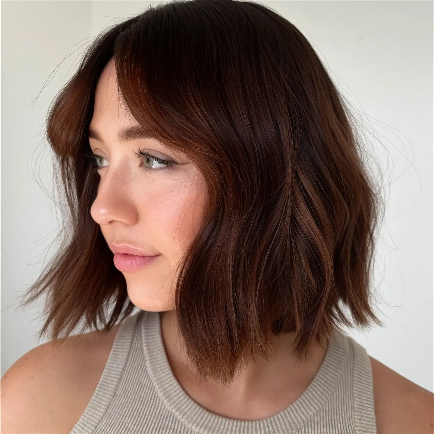 Tousled chin-length bob with dimensional red-brown hair color