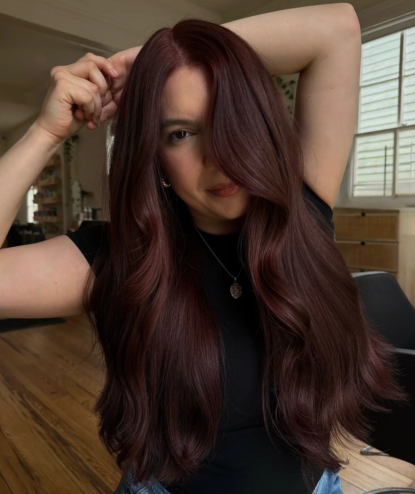 Long glossy waves with a dark burgundy hair color