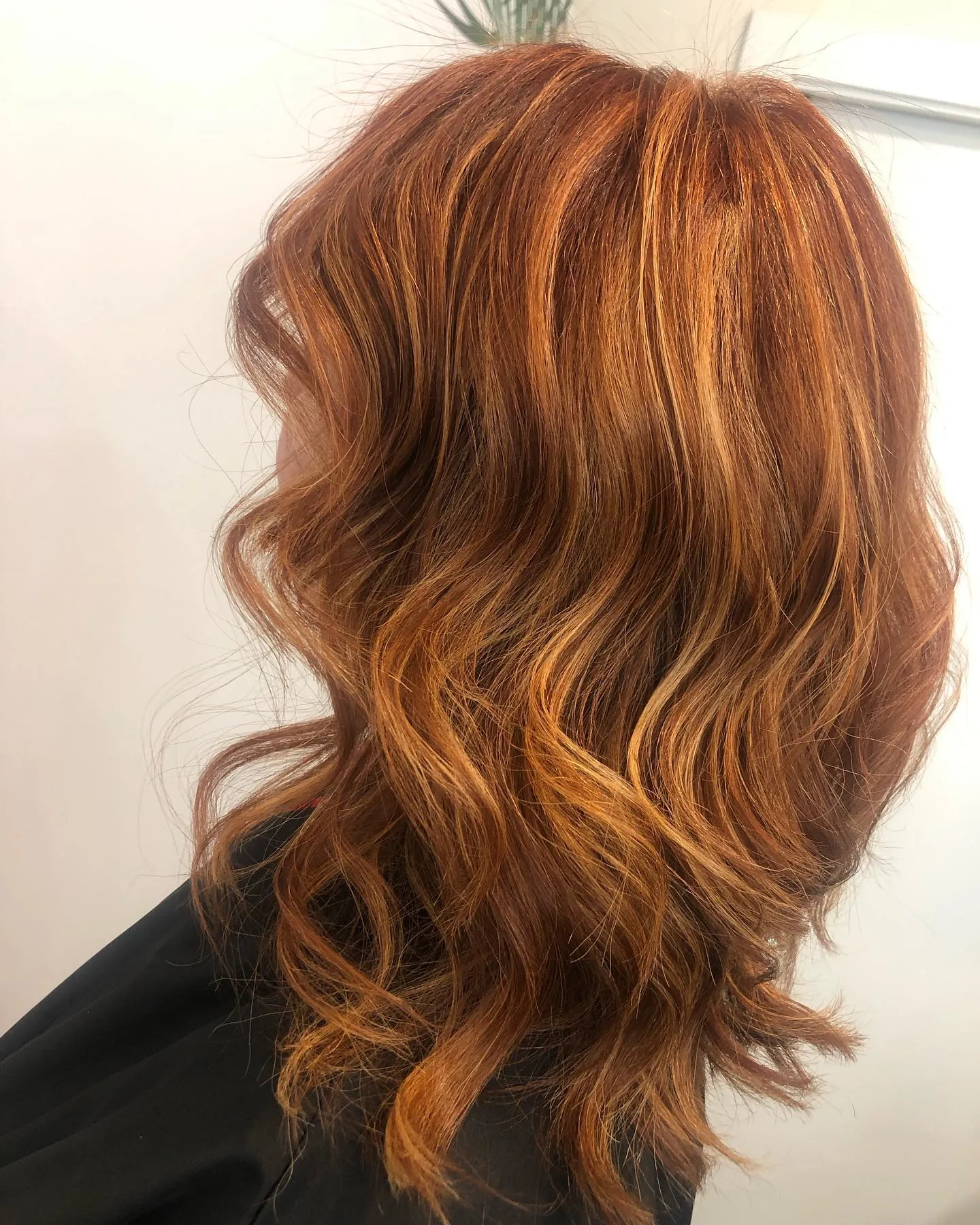 Soft copper ribbons through shoulder-length wavy hair