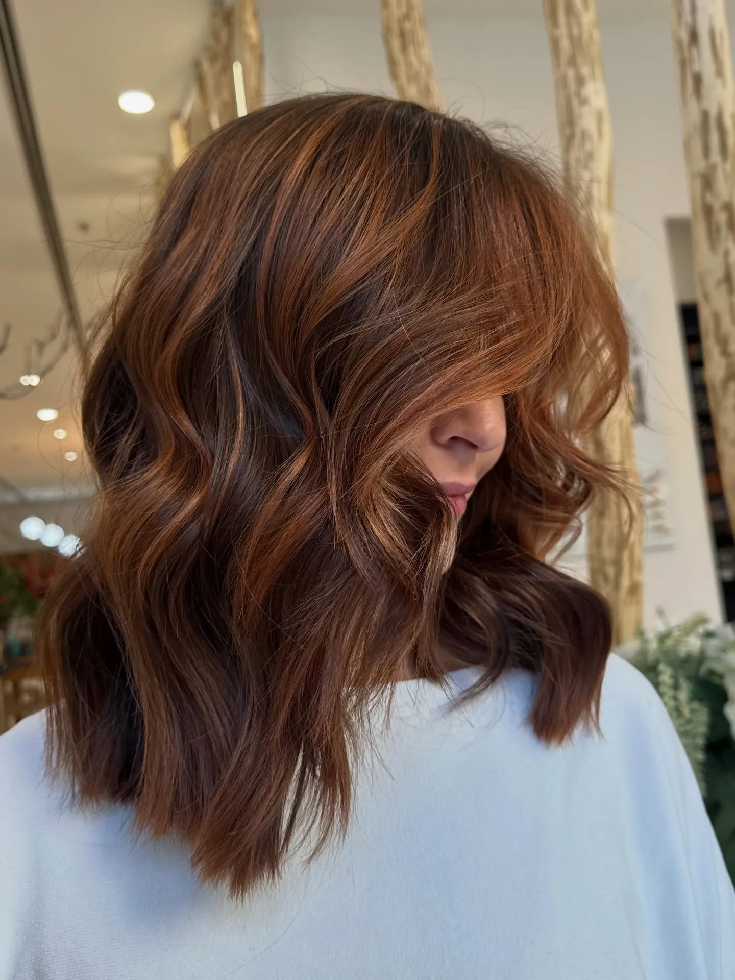 Subtle copper balayage on long layered brunette waves