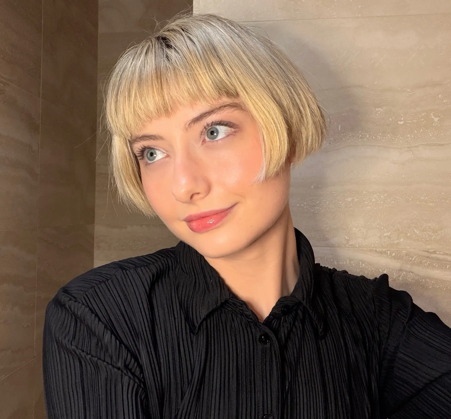 Rounded blonde ear-length bob with full straight fringe