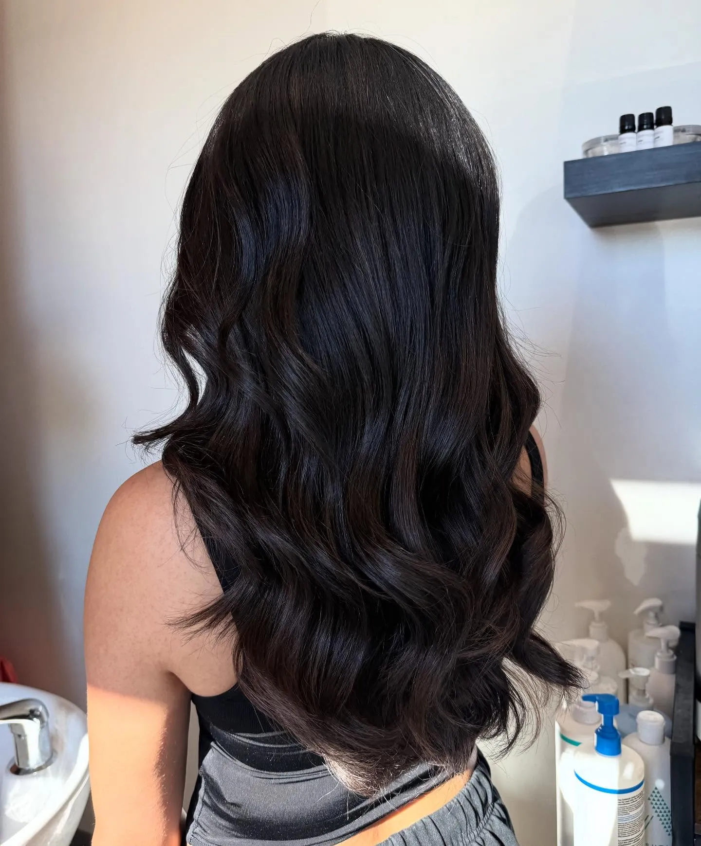 Long near-black brunette hair with soft polished waves
