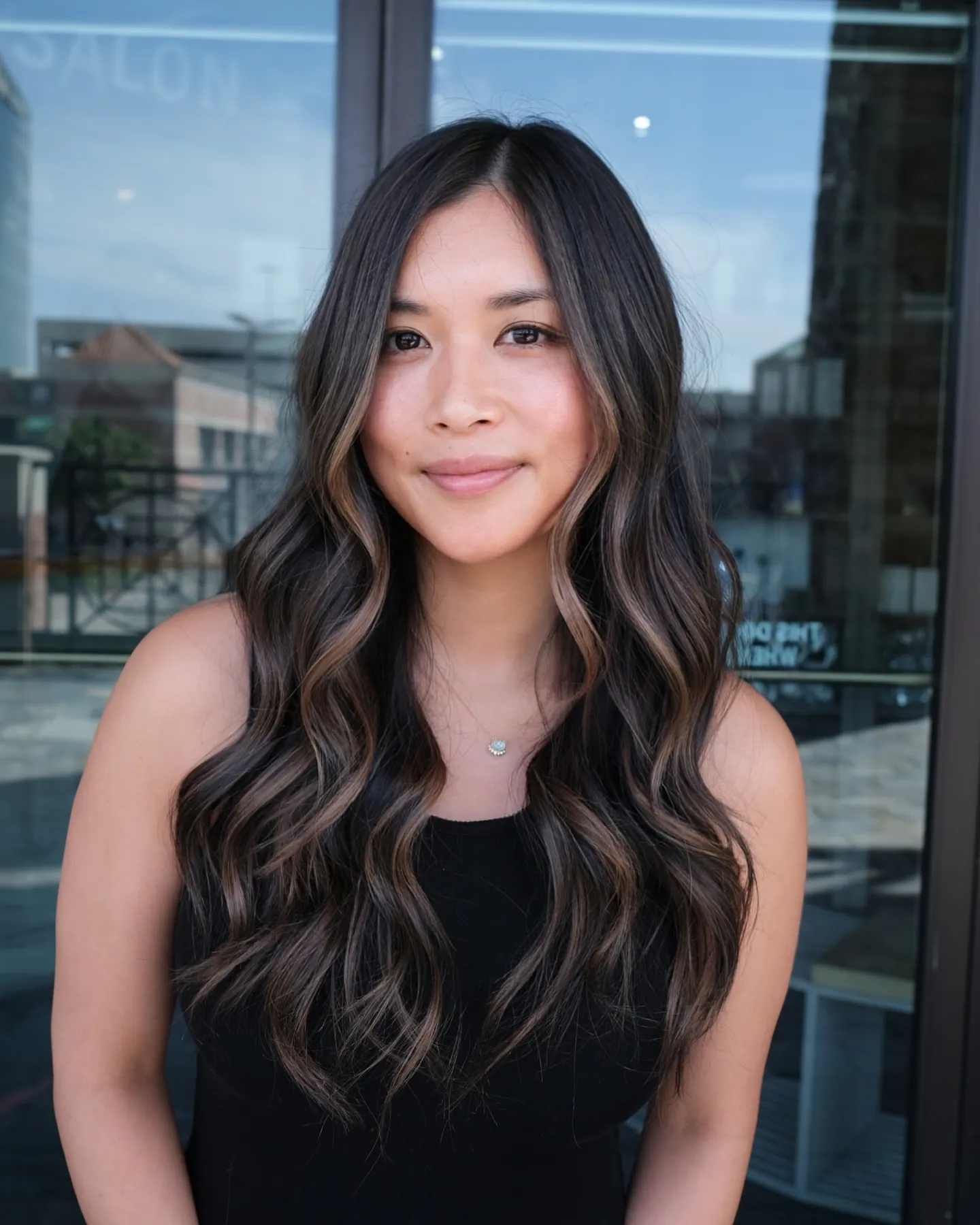Long dark brunette waves with subtle lighter face-framing pieces