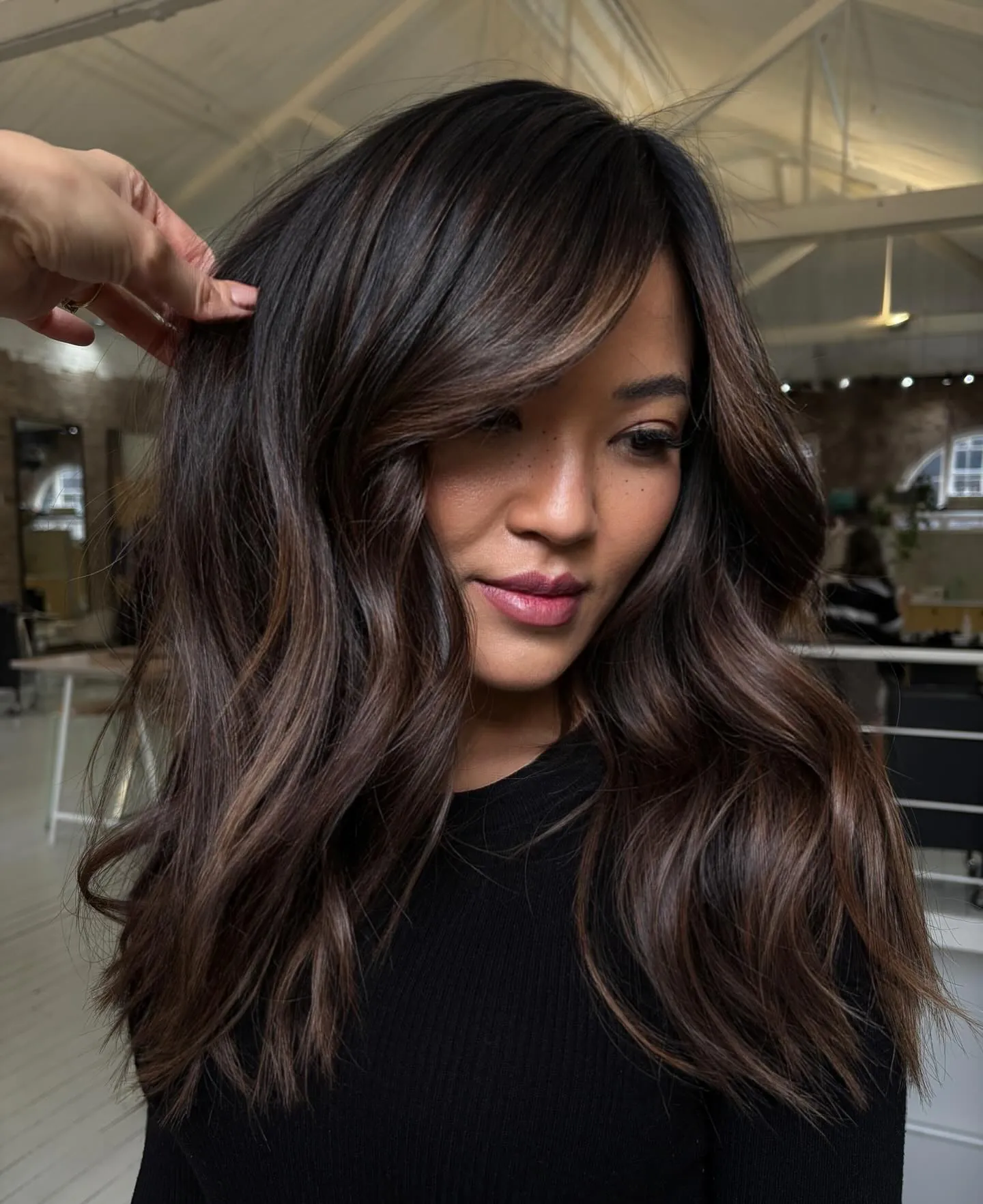 Dark brunette shoulder-length layers with a side-swept fringe