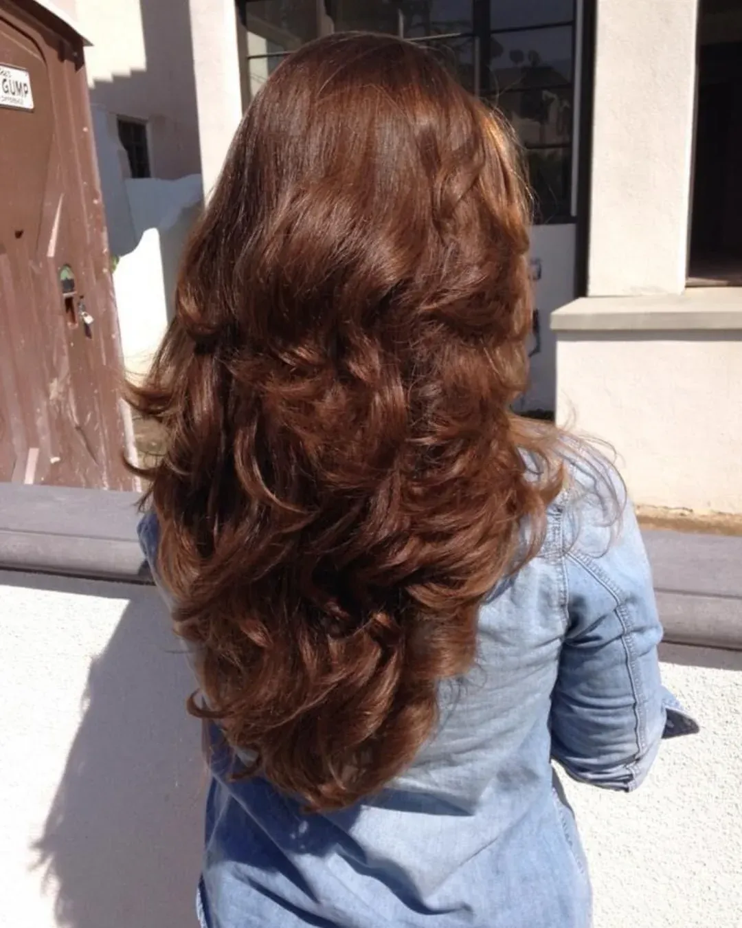 Long copper-brown hair with layered waves viewed from the back