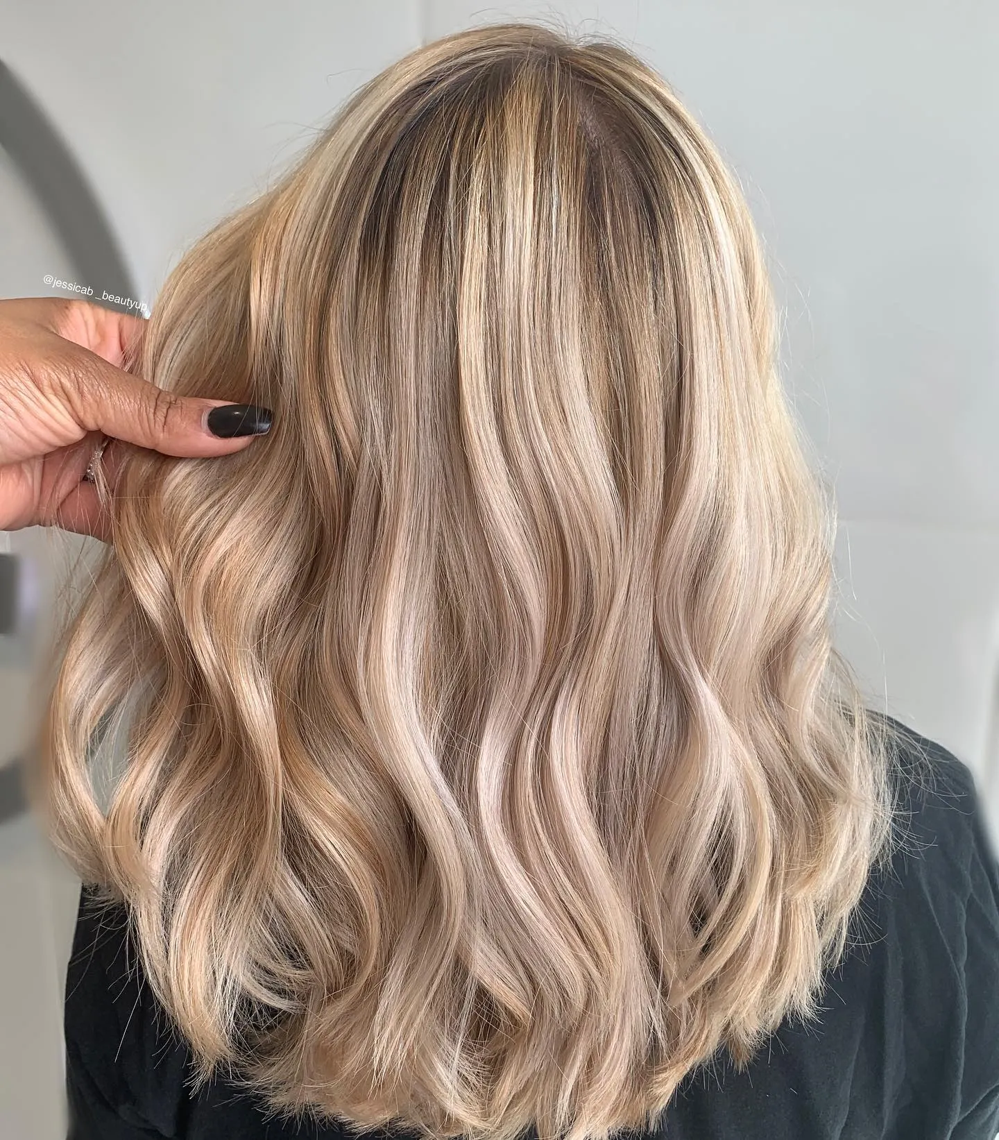 Back view of soft beige blonde waves with root shadow