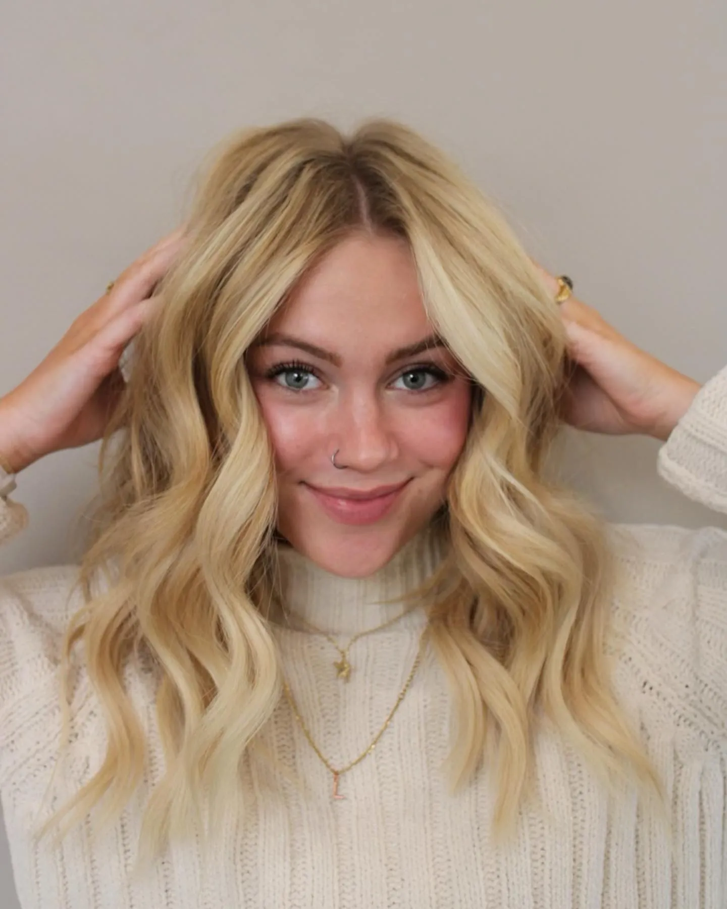 Bright blonde medium waves with hands in hair