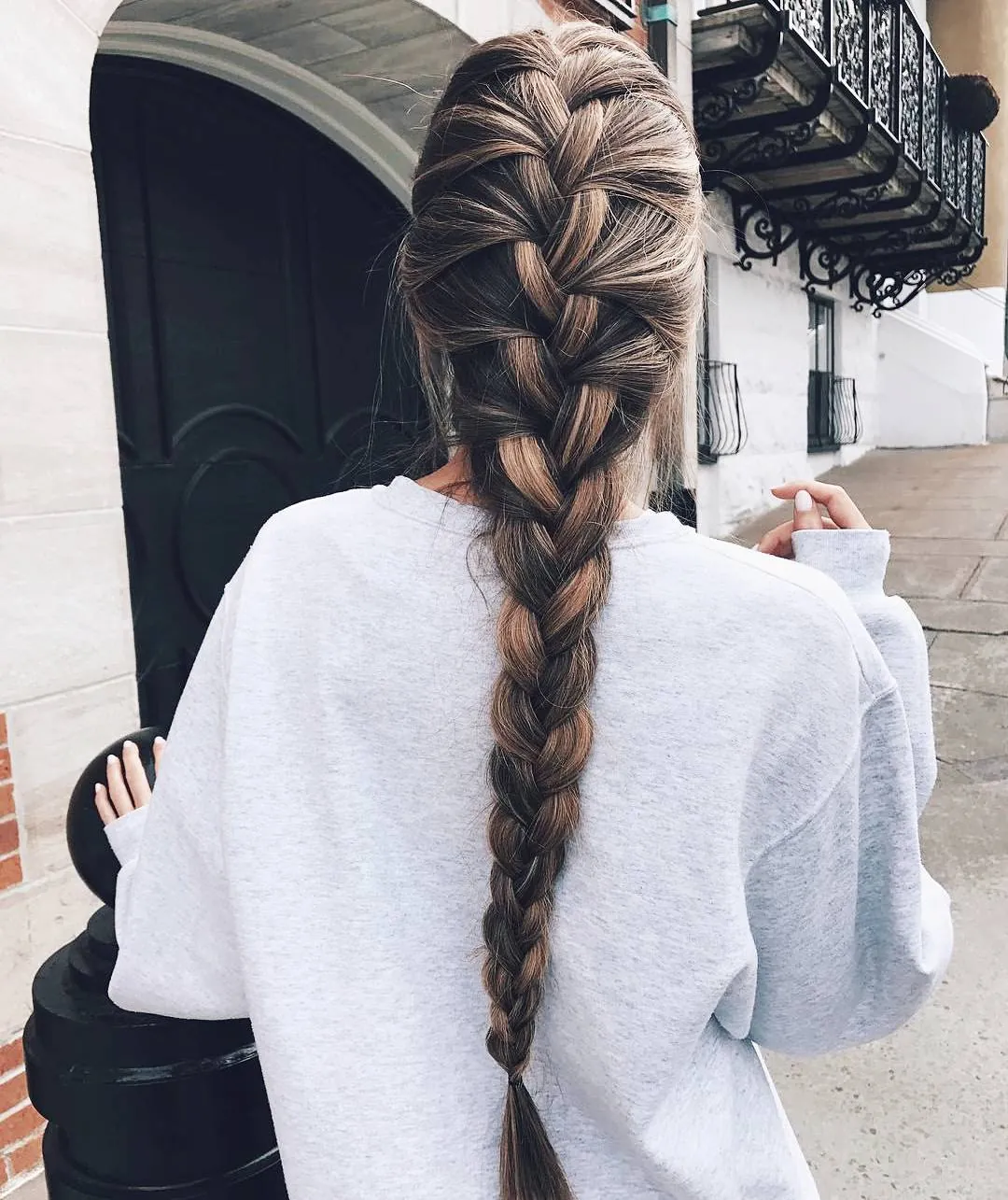 Two loose half-up braids over long wavy hair