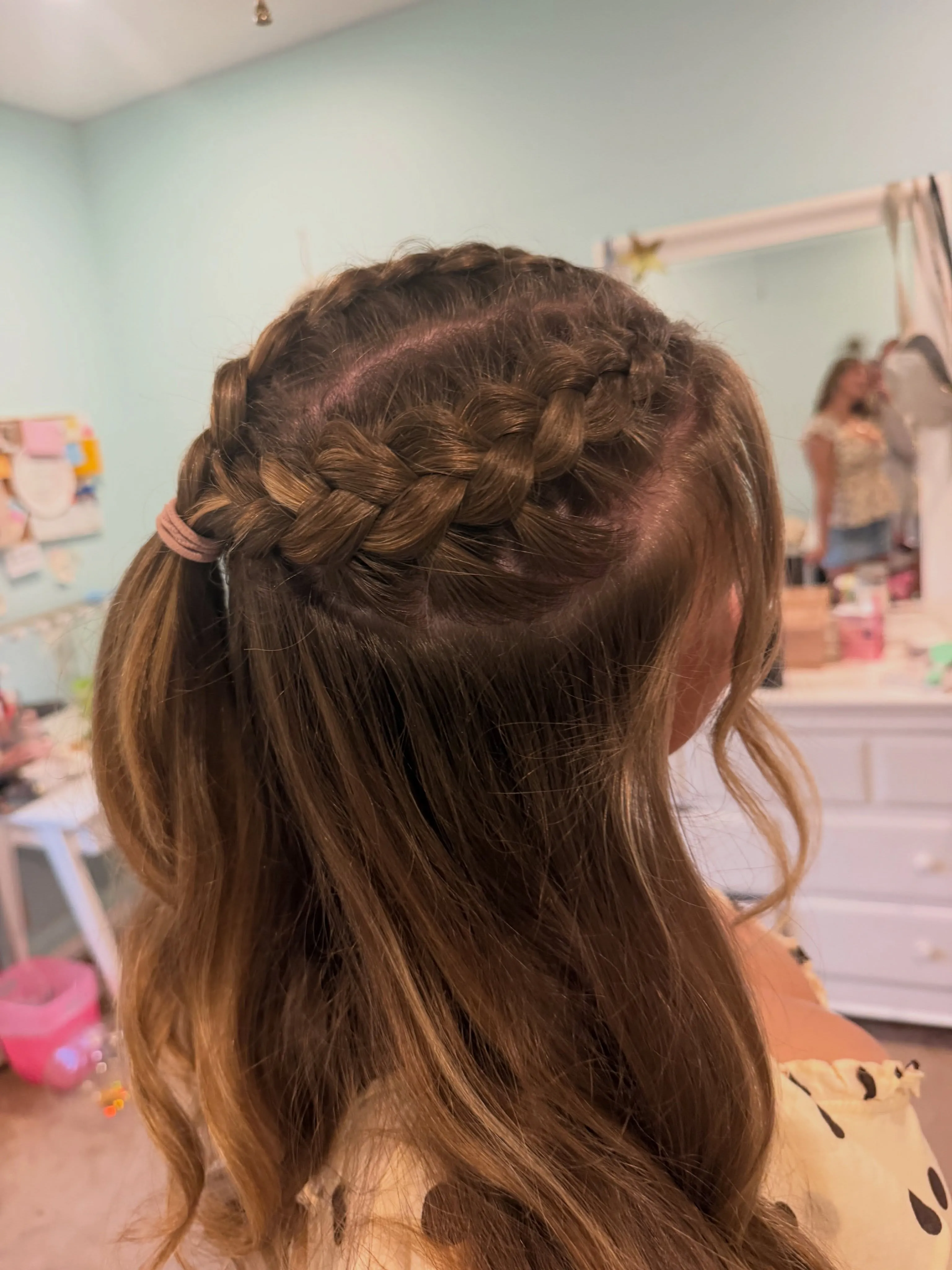 Half-up center braid finished with a large ribbon bow