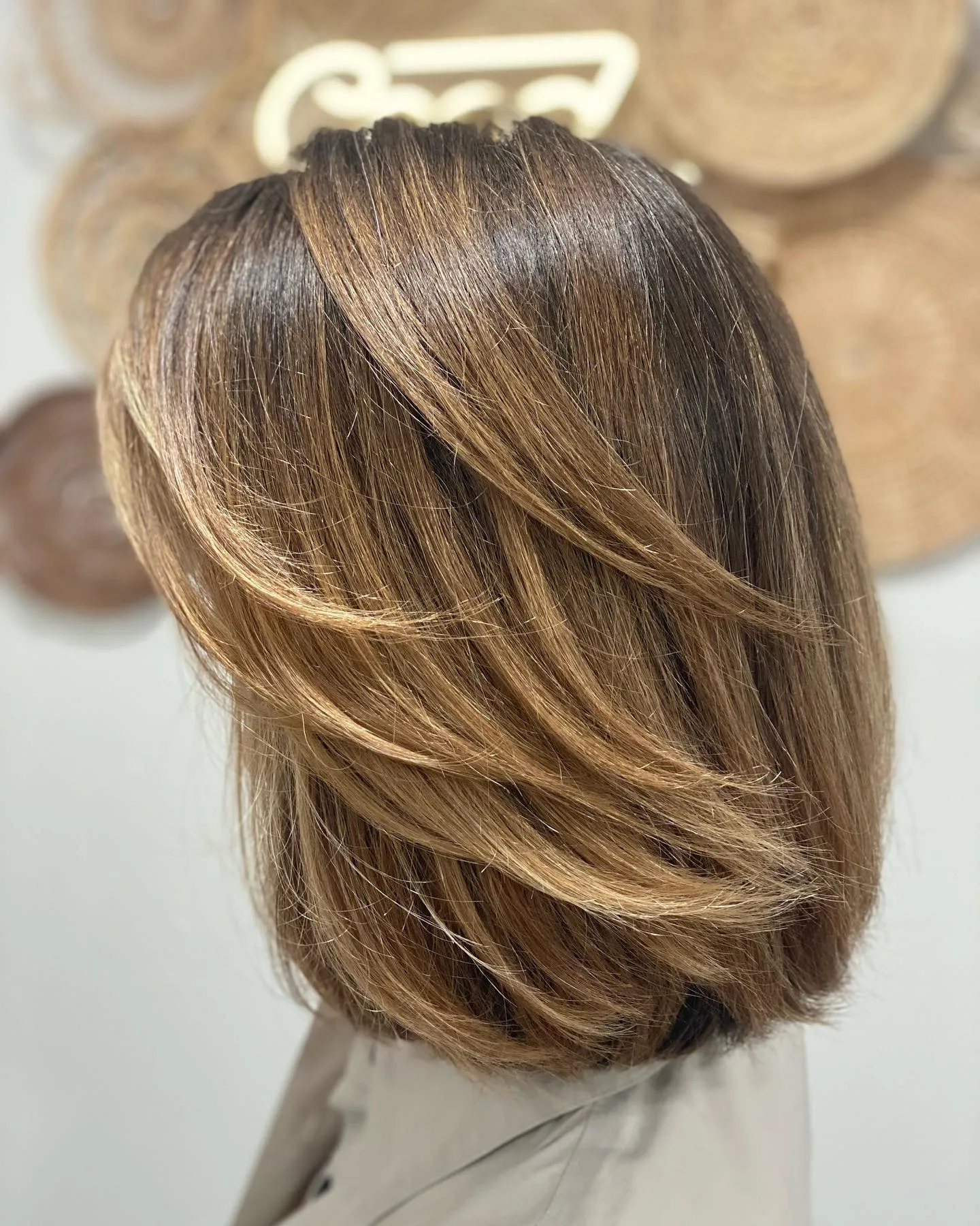Sleek layered bob with dark roots to lighter brown ends