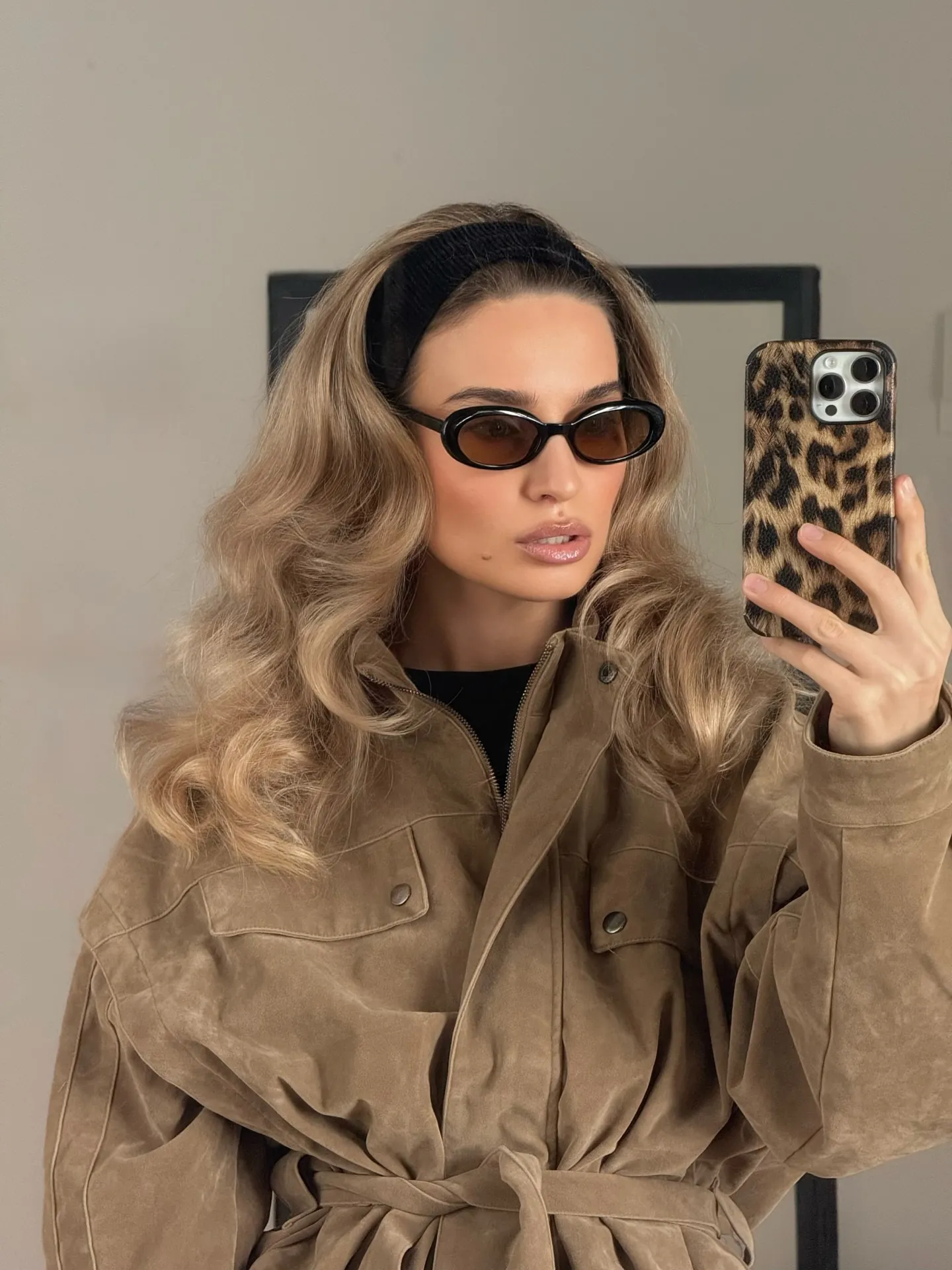 Long blonde waves pushed back with a wide black padded headband
