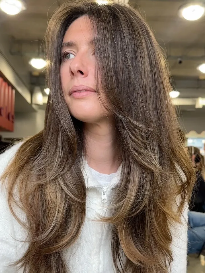 Long centre-parted brunette hair with soft face-framing layers