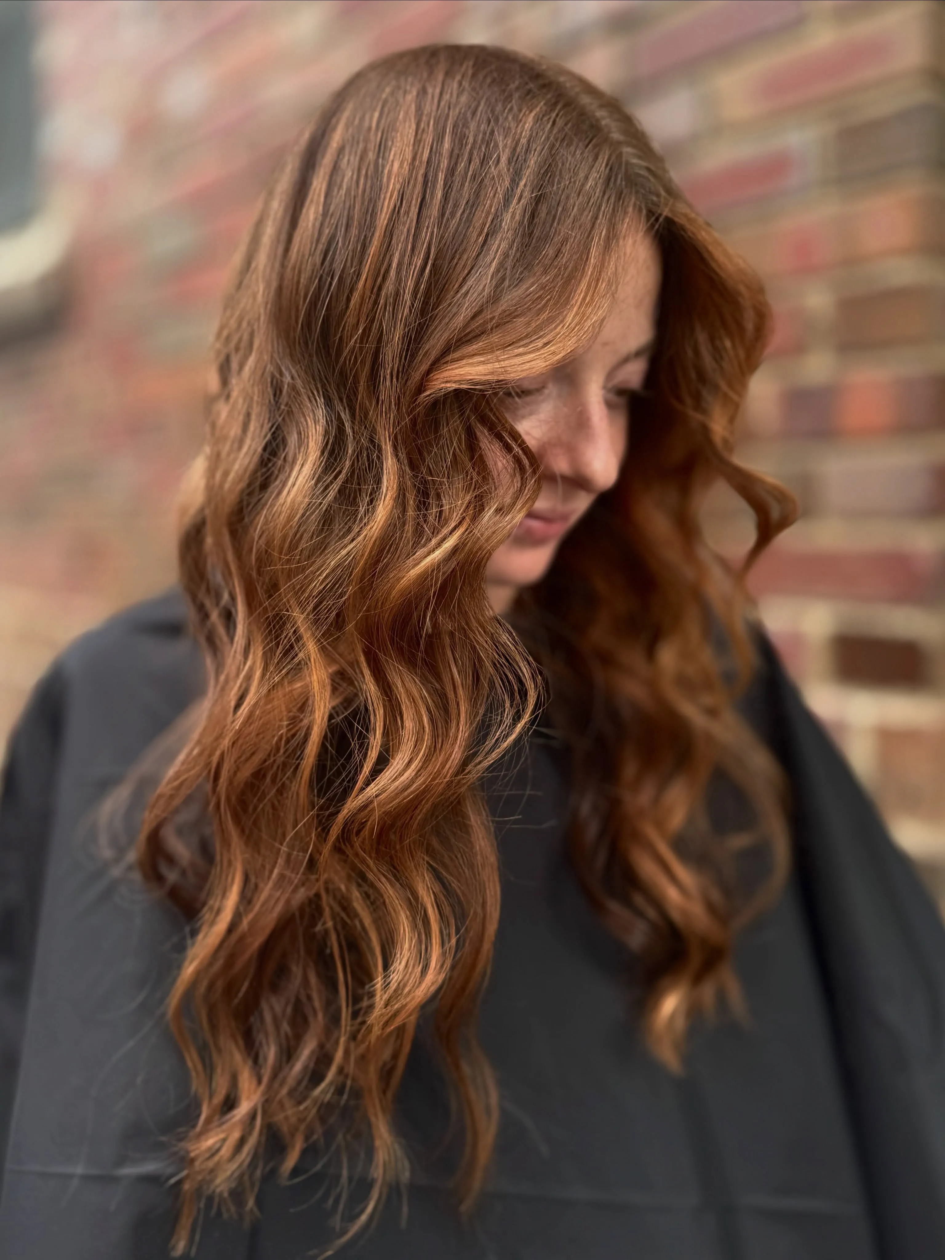 Long auburn hair styled in loose tousled waves