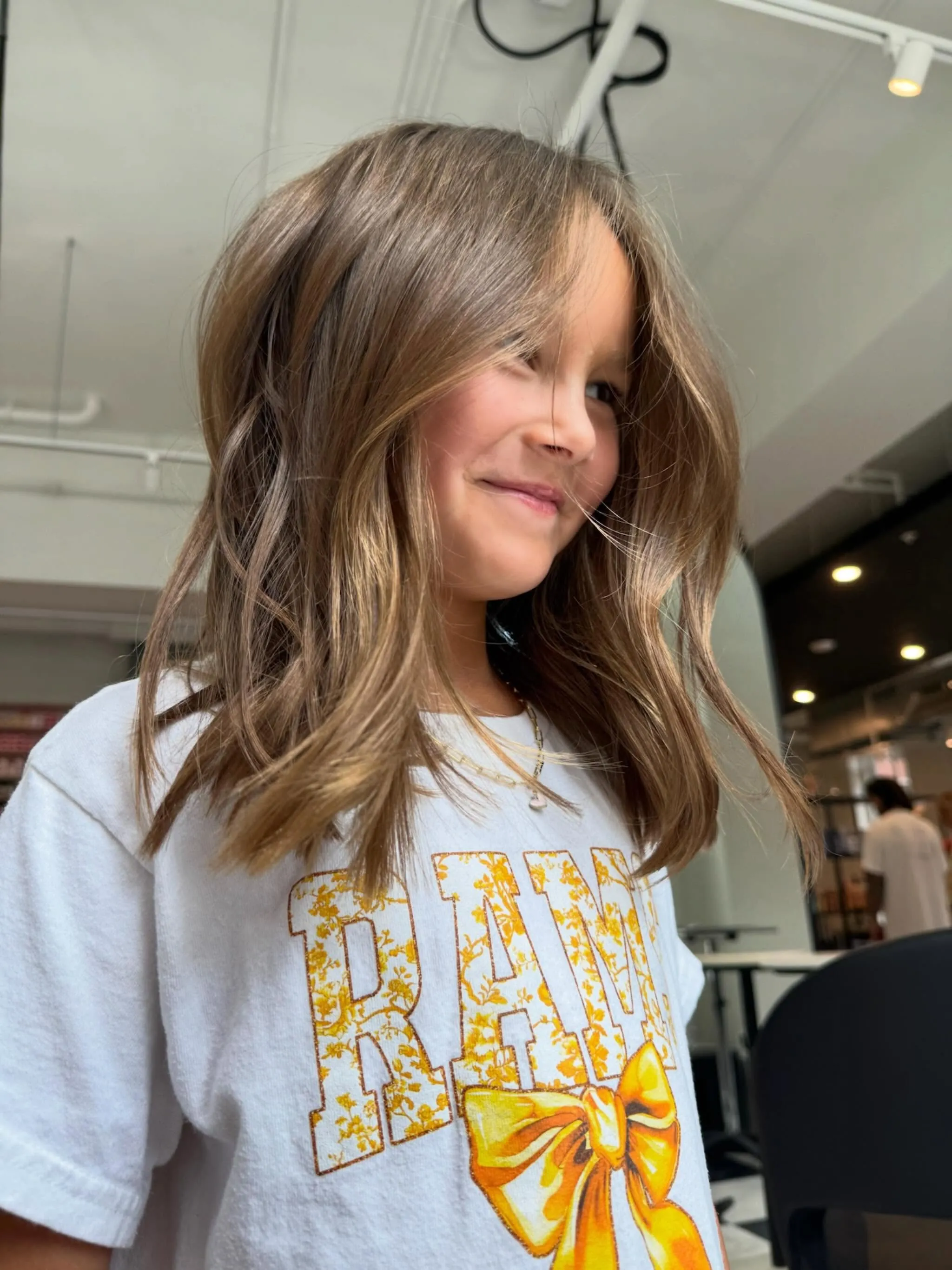 Long brown hair with soft waves and face-framing layers