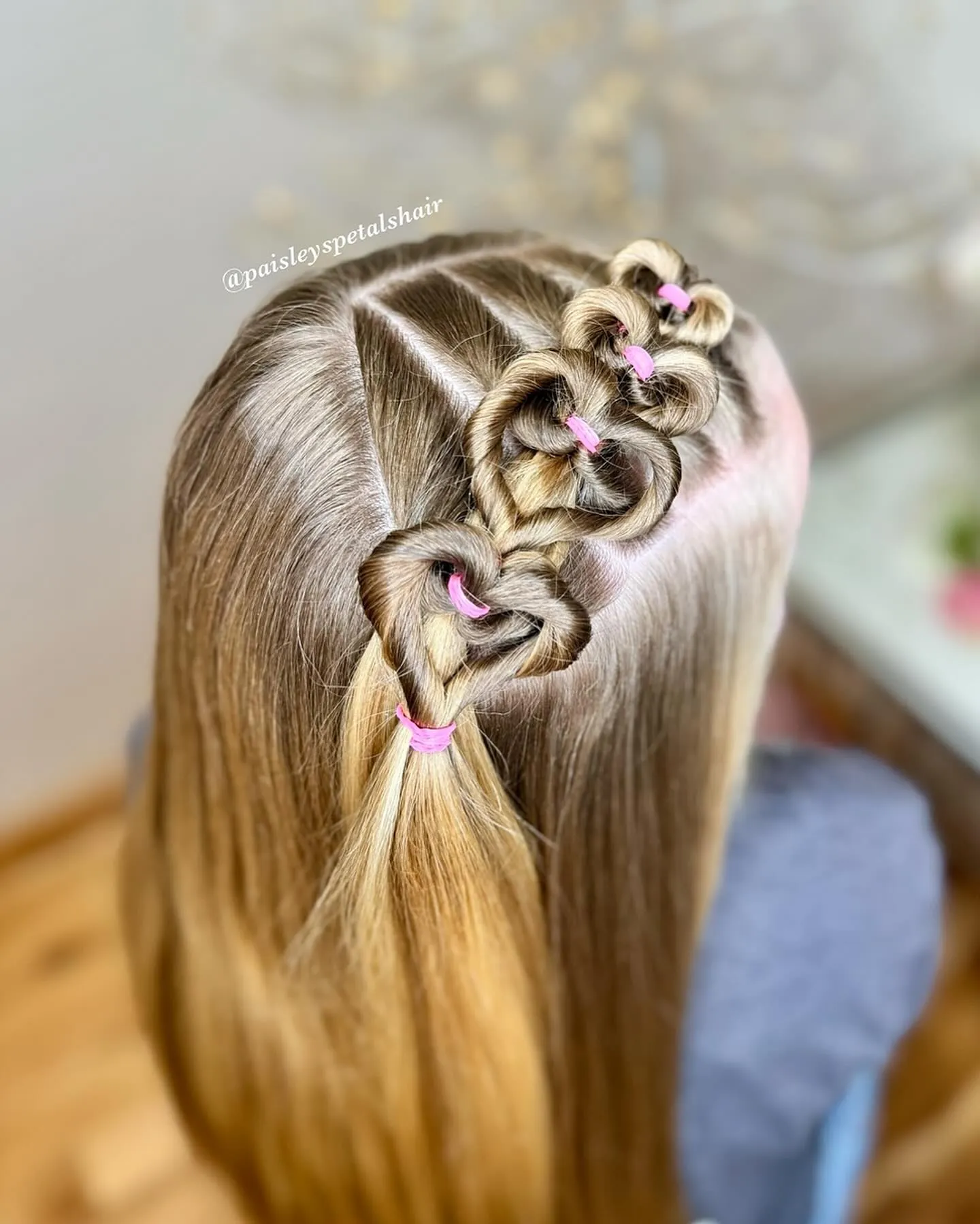 Half-up braid made from hair bows secured with pink elastics