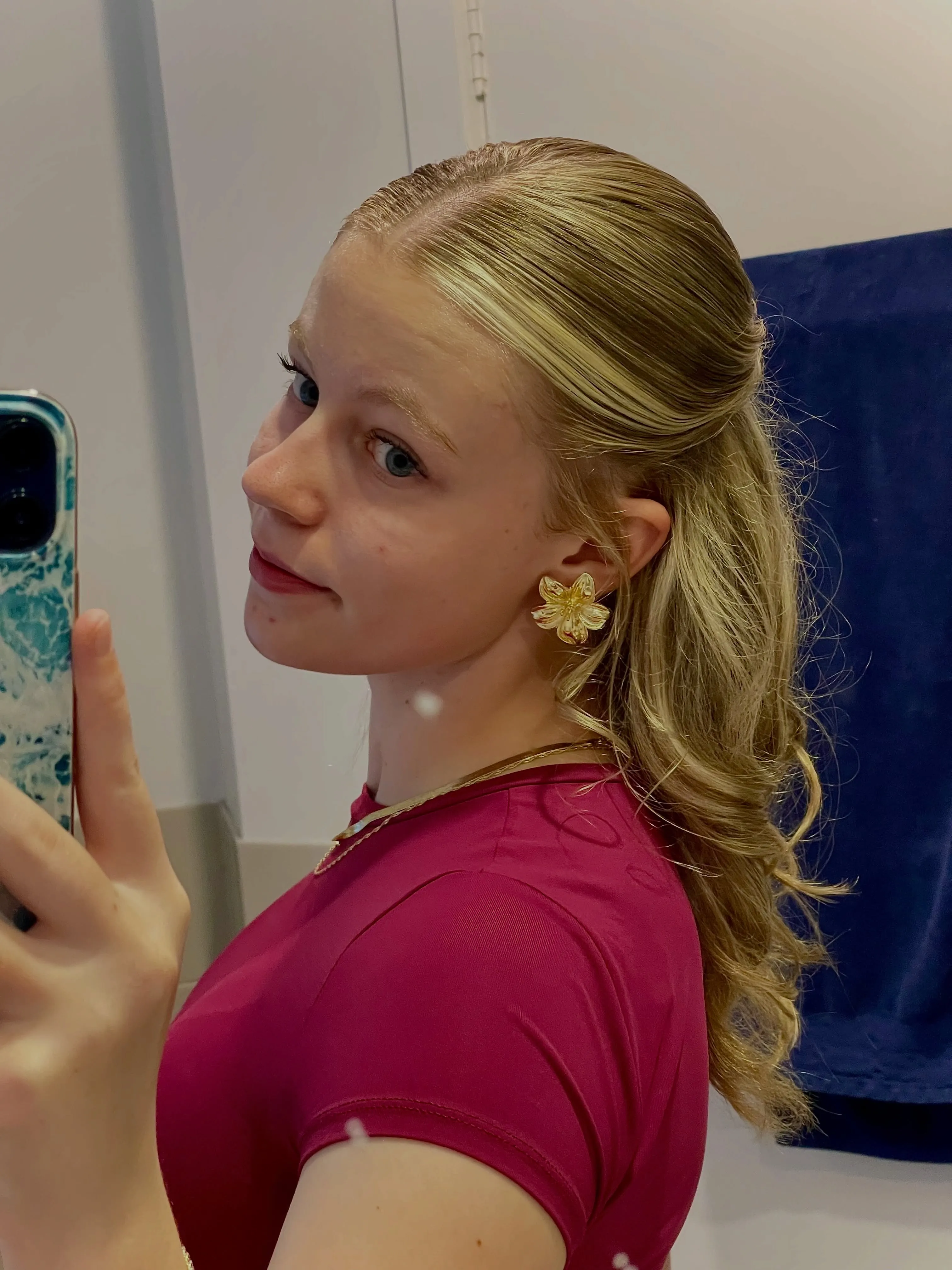 Sleek half-up ponytail with softly curled blonde ends
