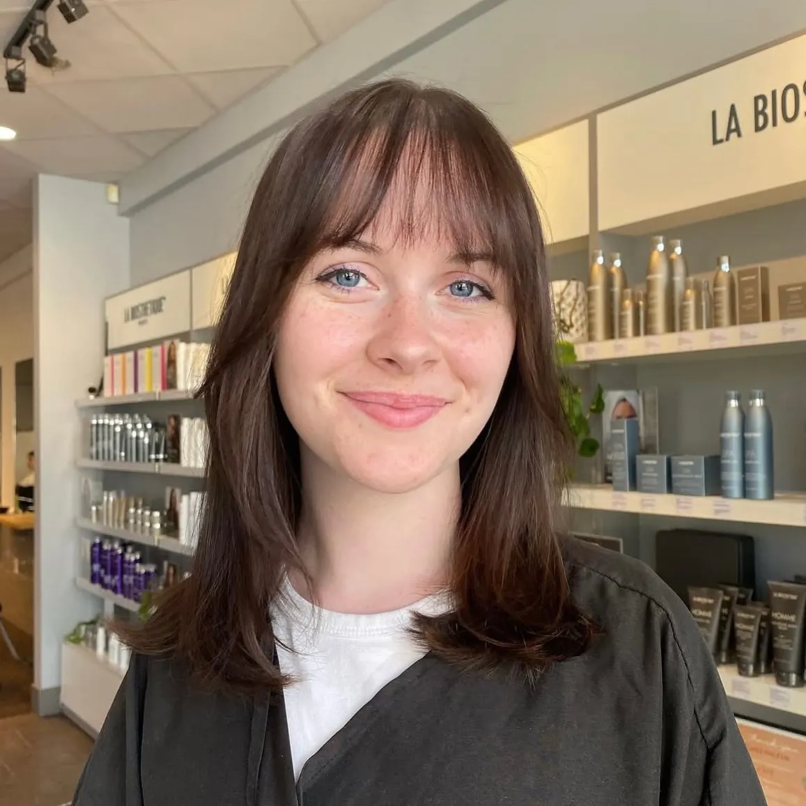 Layered brown lob with full bangs and softly curved ends