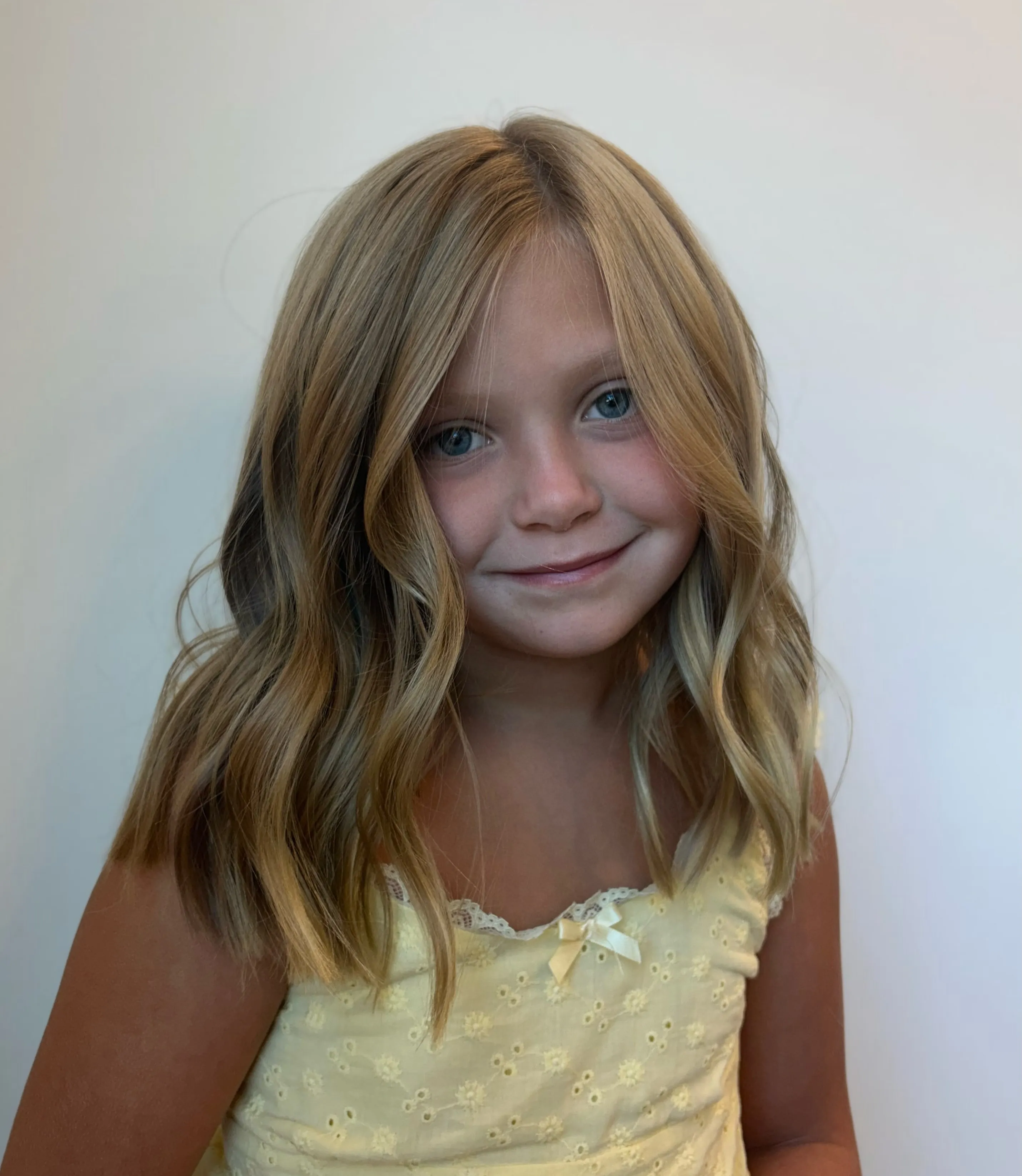 Blonde shoulder-length waves with a center part