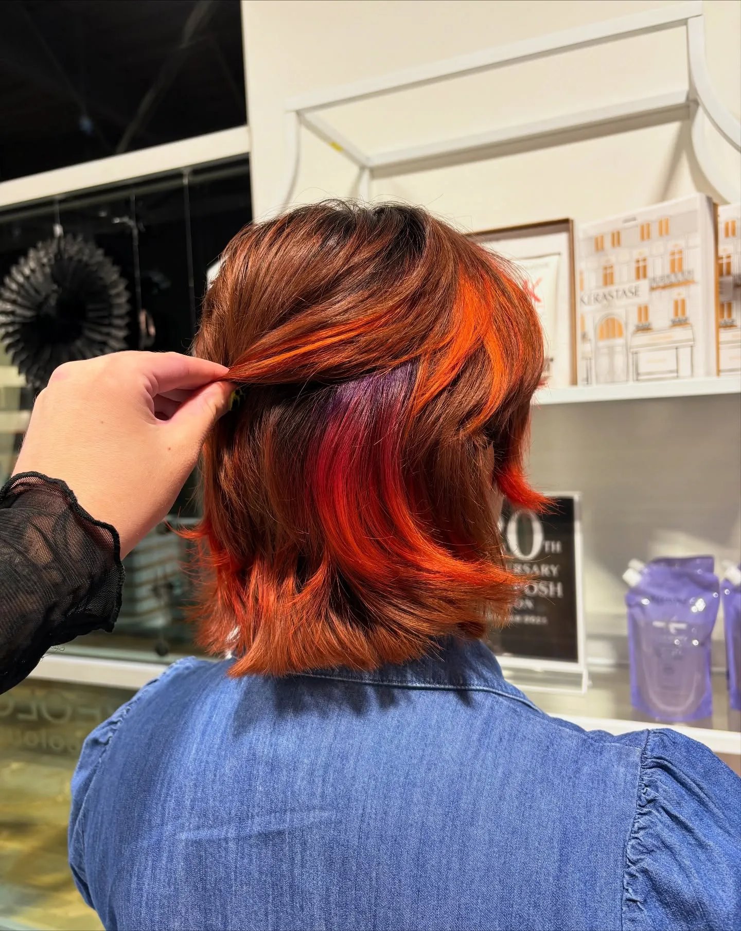 Short auburn bob with bright orange and red colour hidden underneath